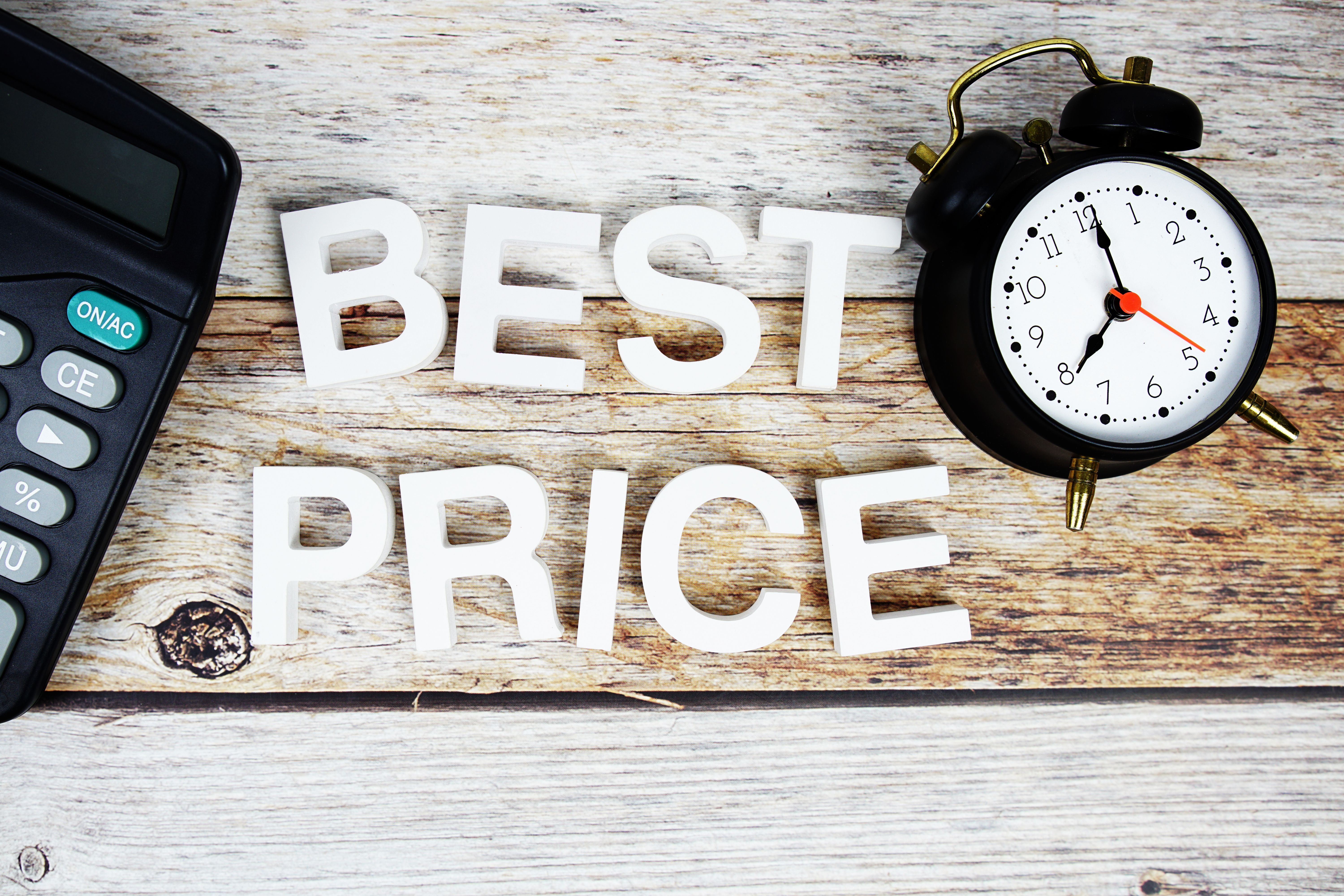 Best Price with alarm clock and calculator alphabet letters on wooden background