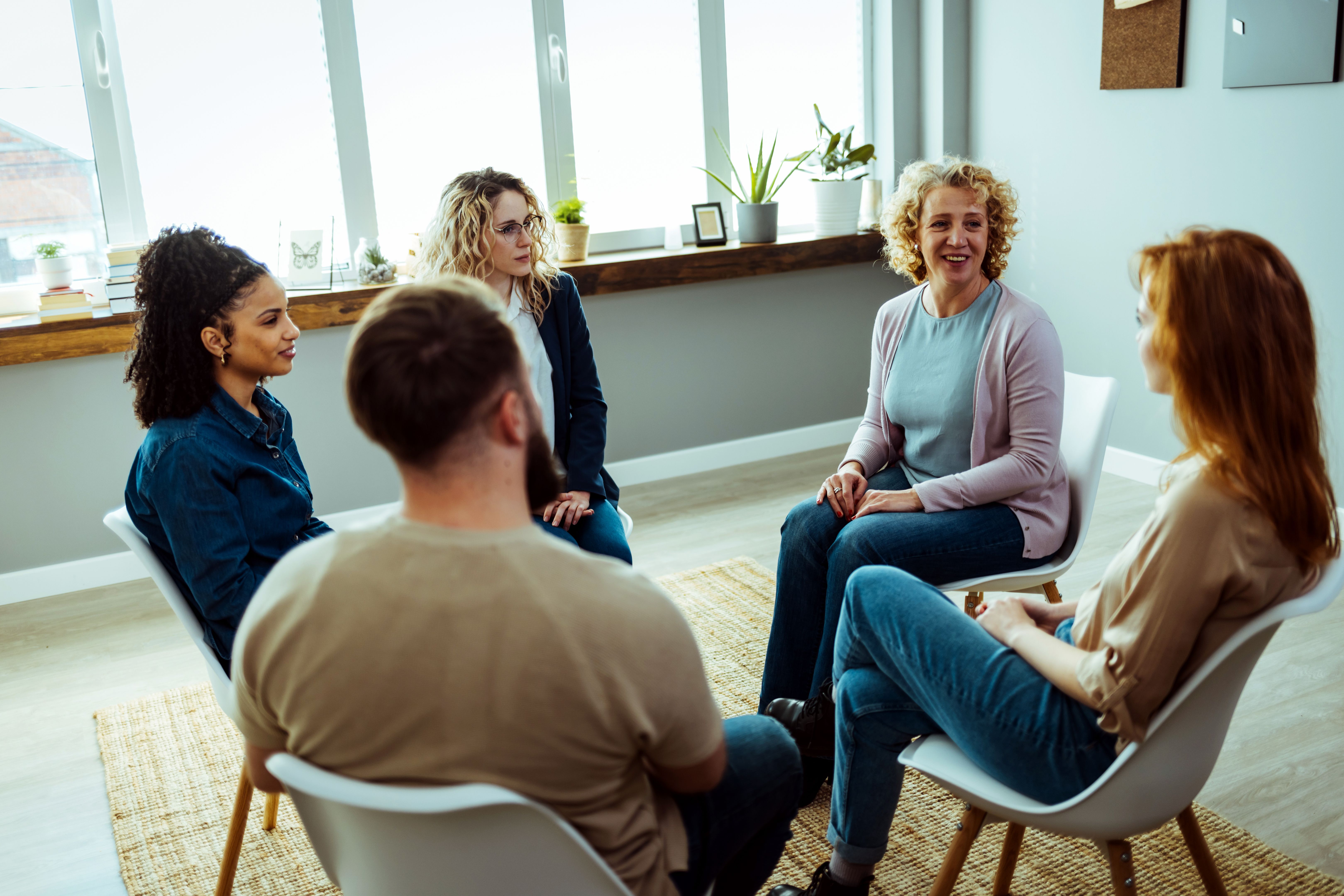 Mental health professional is sitting with people at community center.