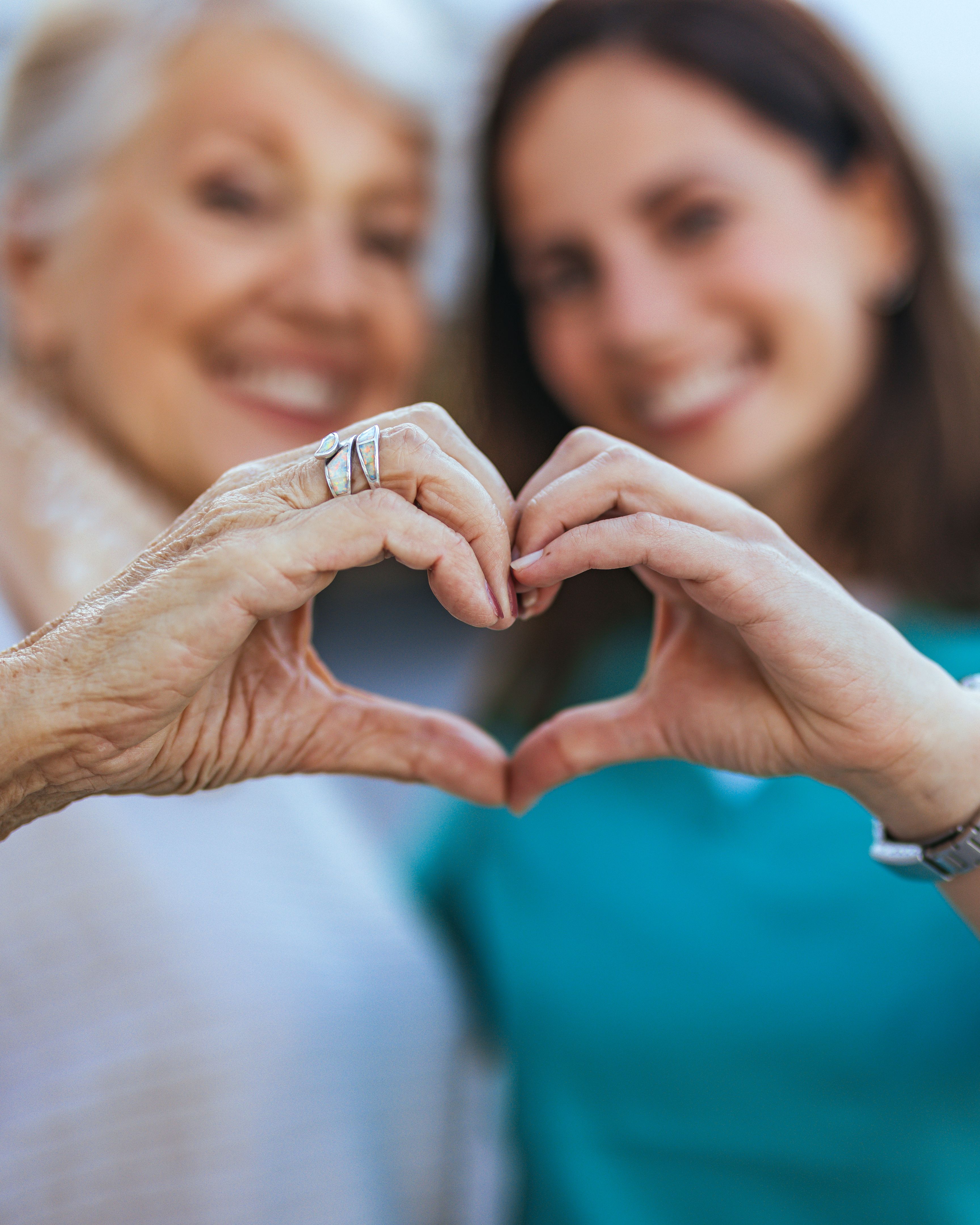 Elderly Woman and Young Woman Making Heart Gesture