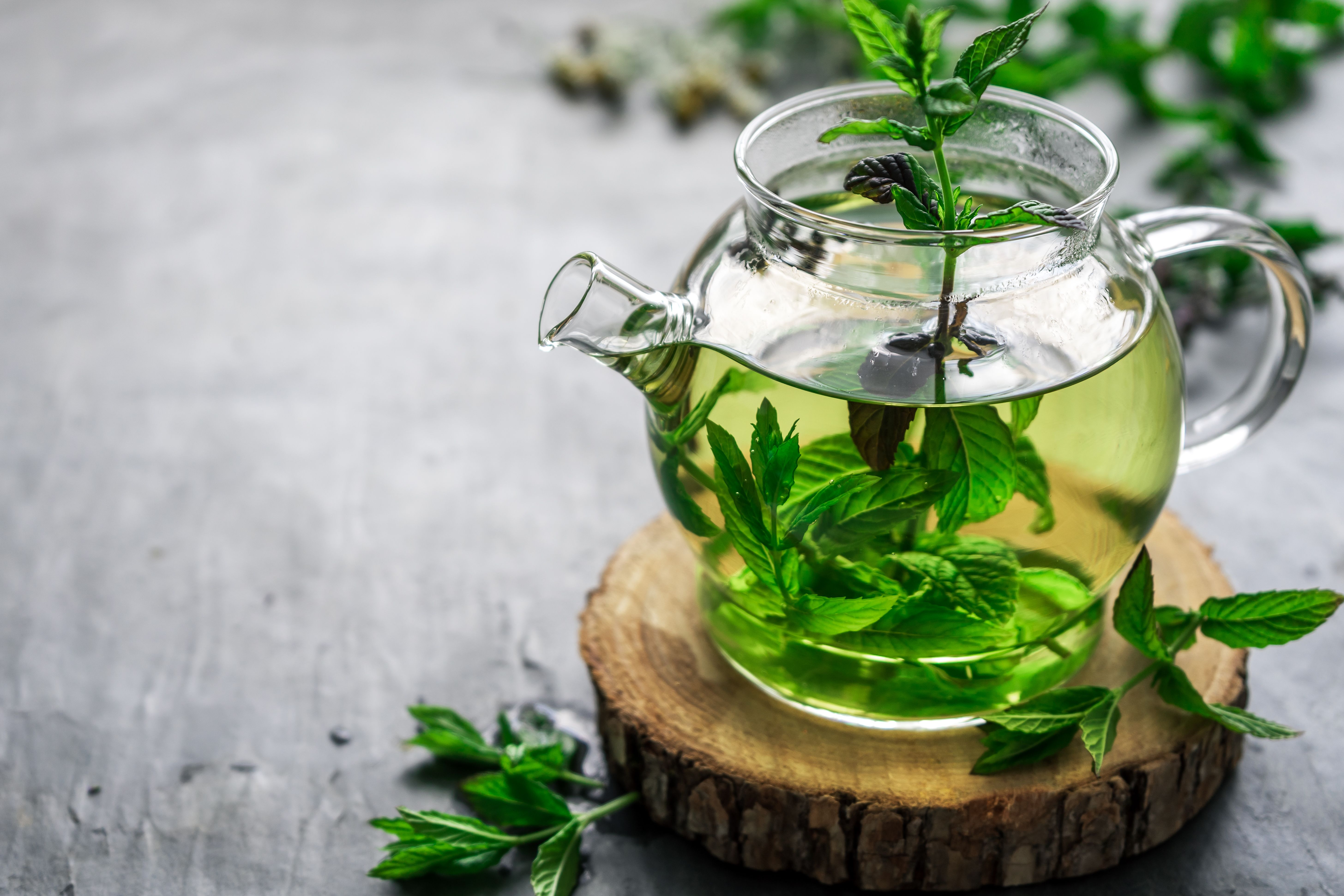 Herbal tea in a glass teapot on a rustic table