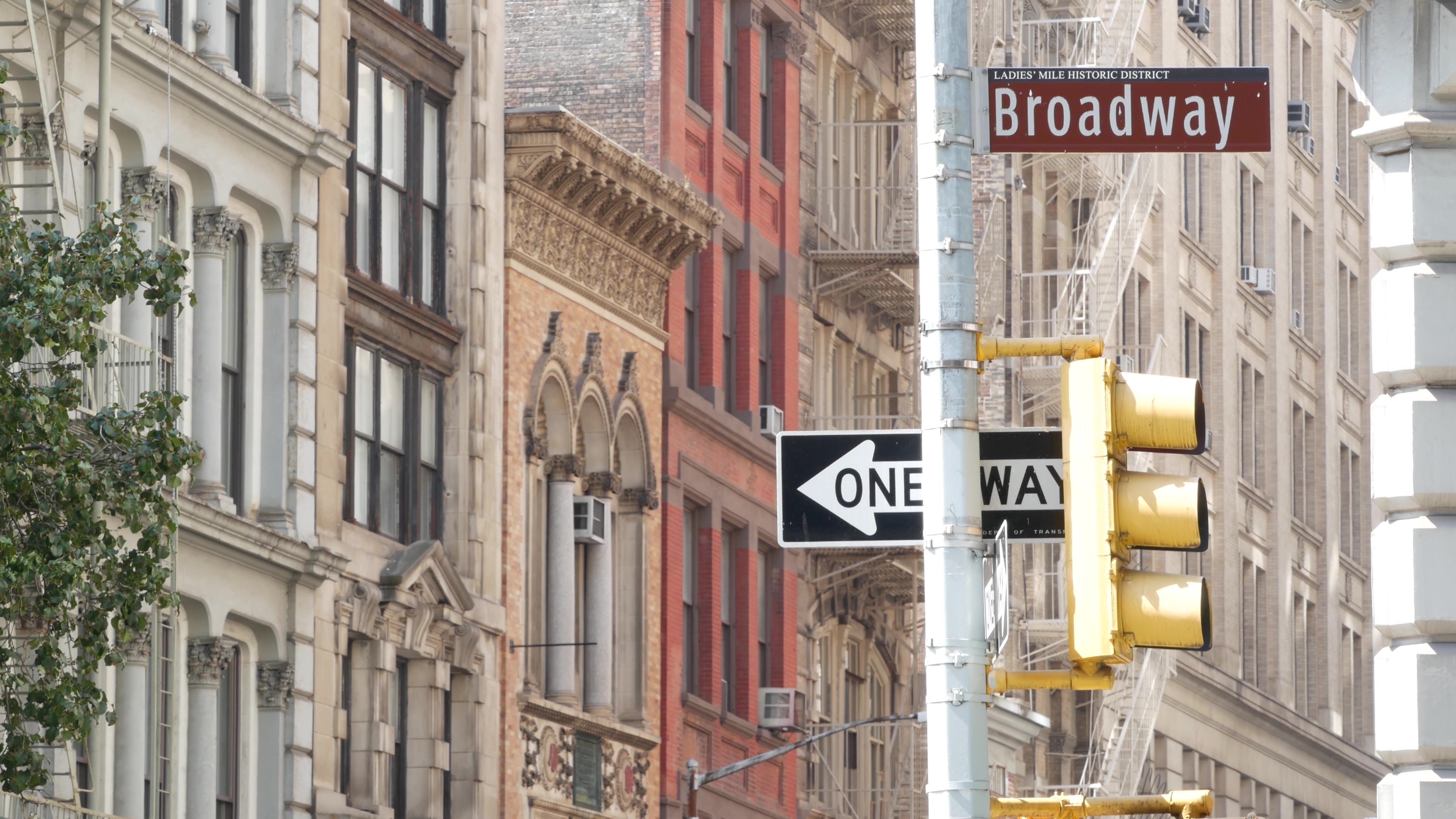 Broadway street road sign, Manhattan midtown architecture, New York City real estate. One way traffic