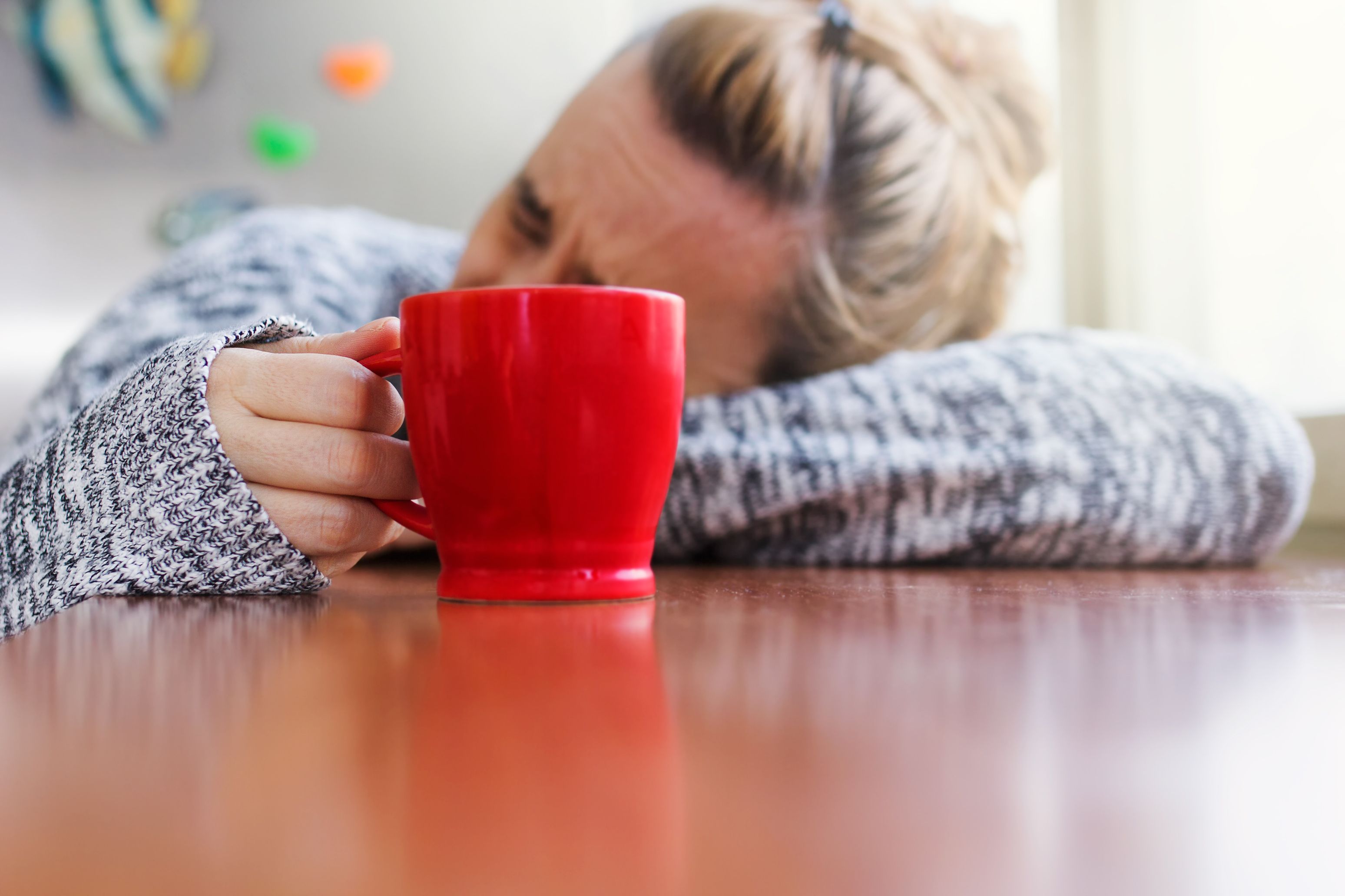 Depressed woman with a cup of coffee in hand Depressed woman with a cup of coffee in hand