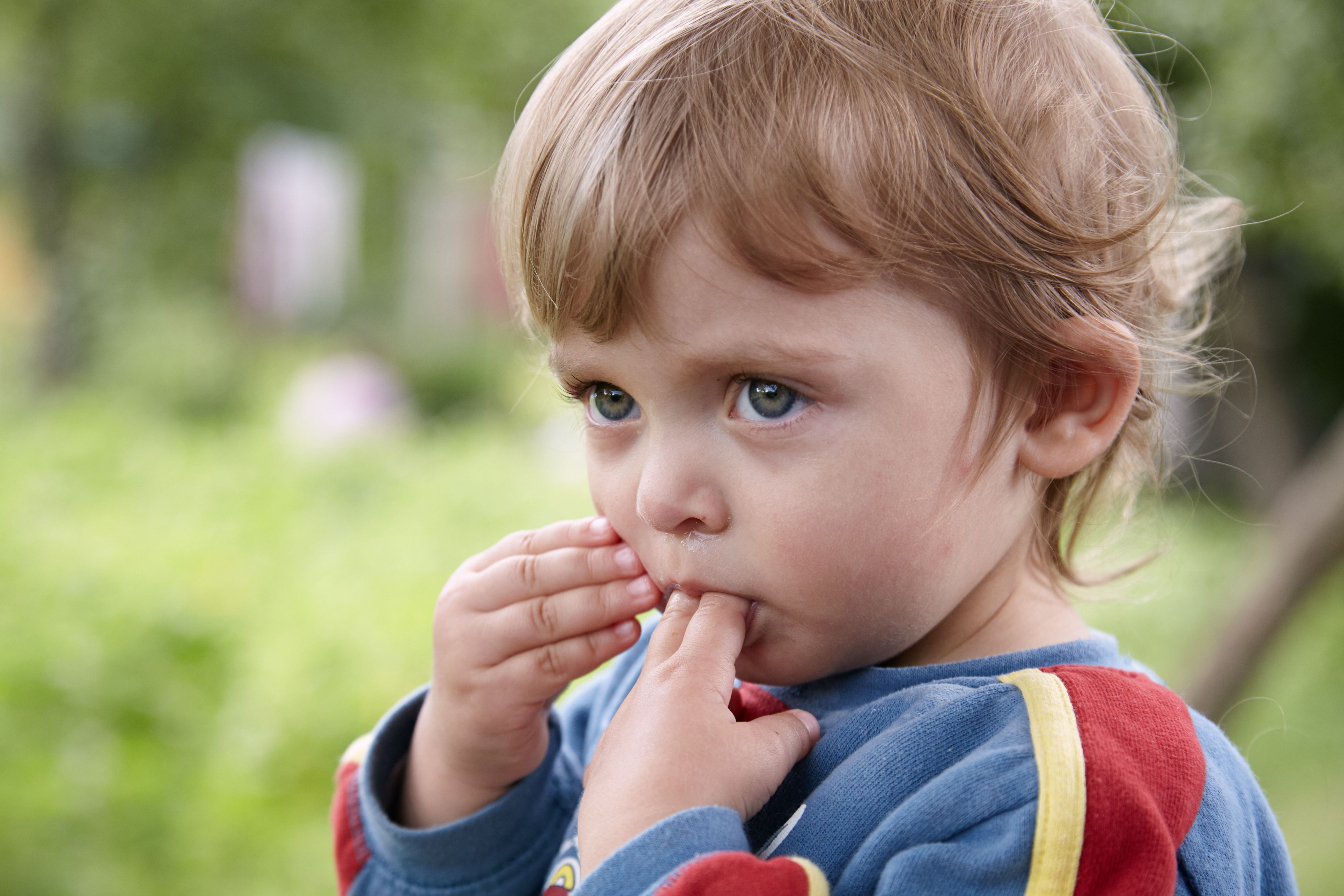Portrait of a little girl sucking two fingers