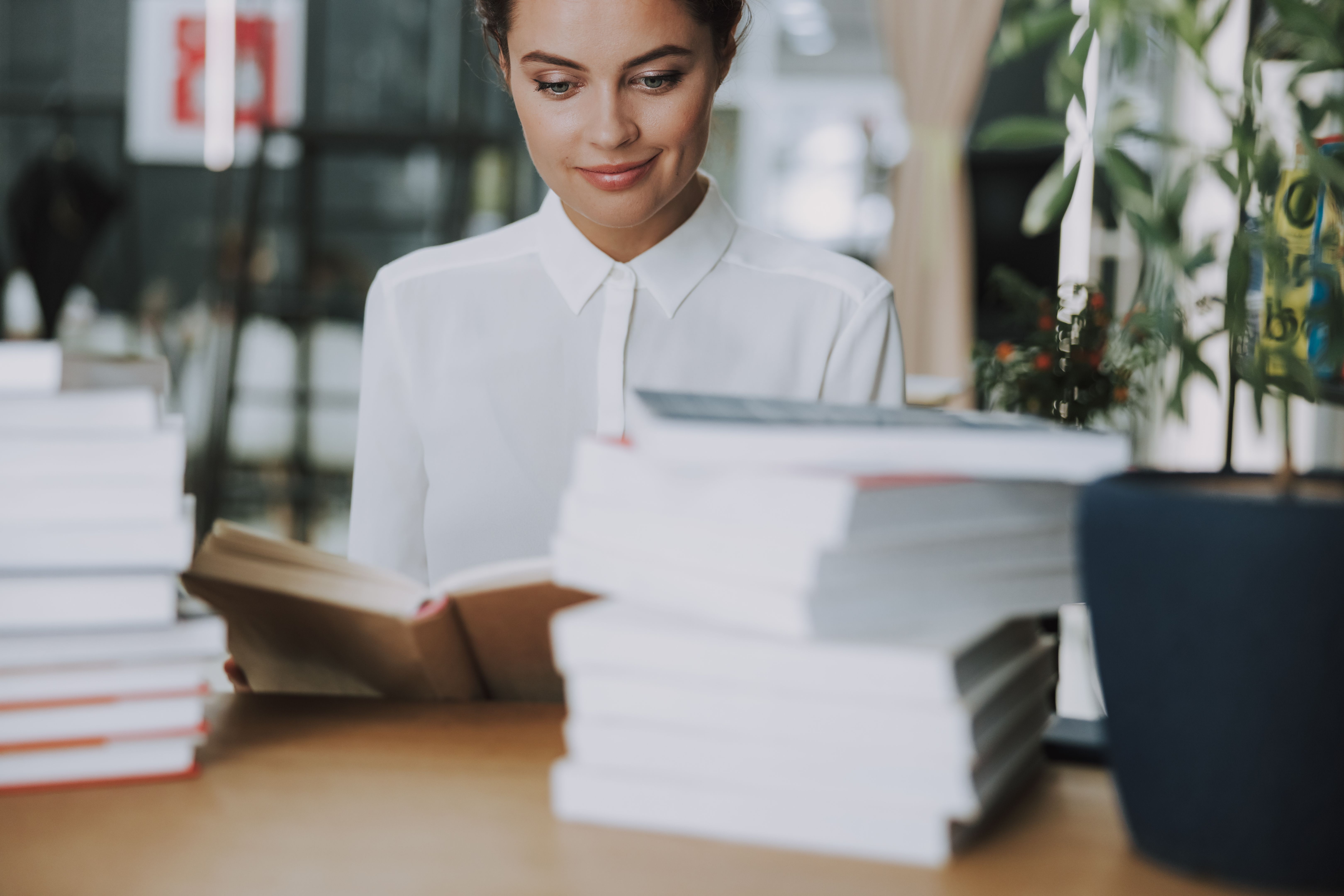 Smiling woman with piles of books stock photo Smiling woman with piles of books stock photo