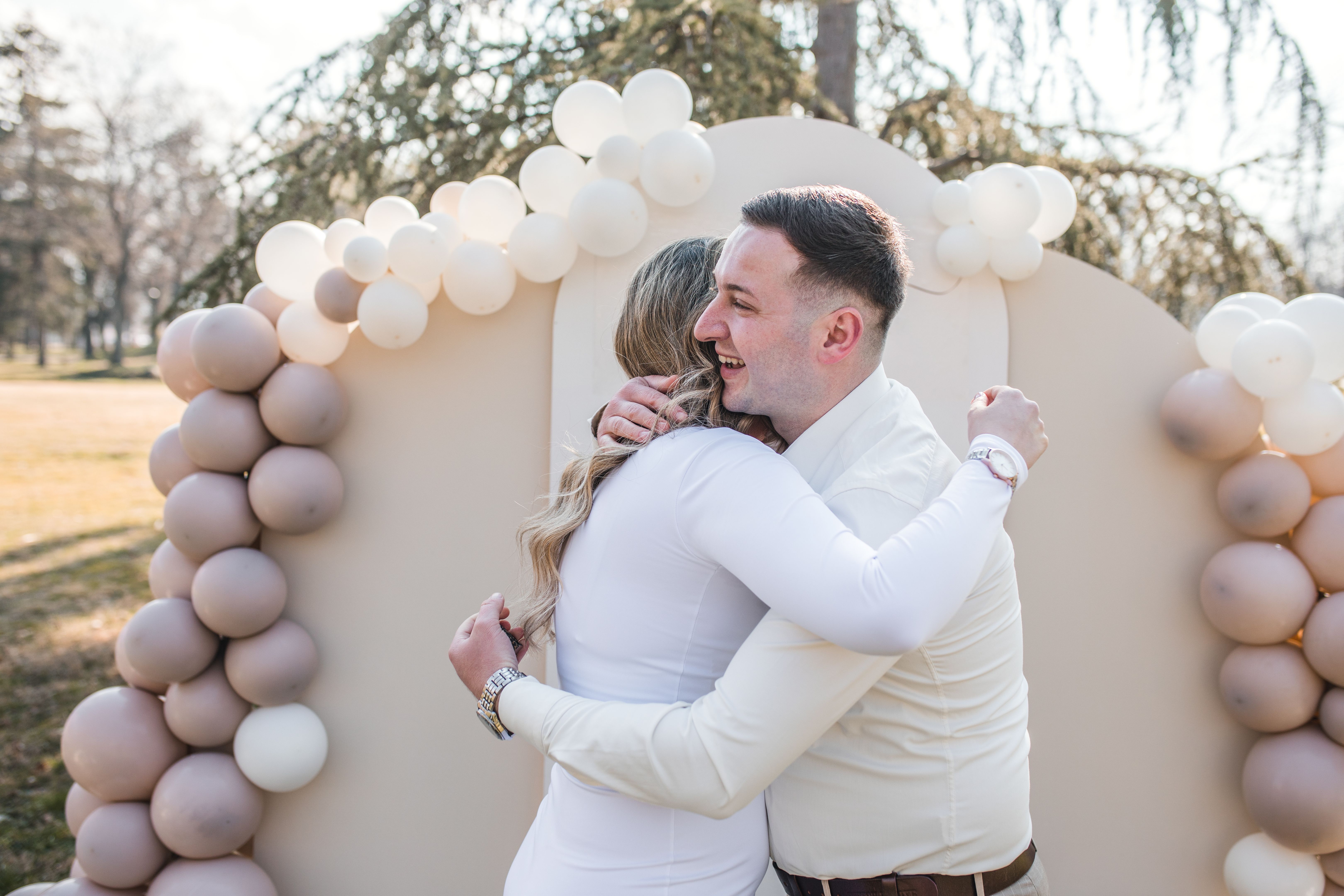A loving couple hugs each other after proposal in the park