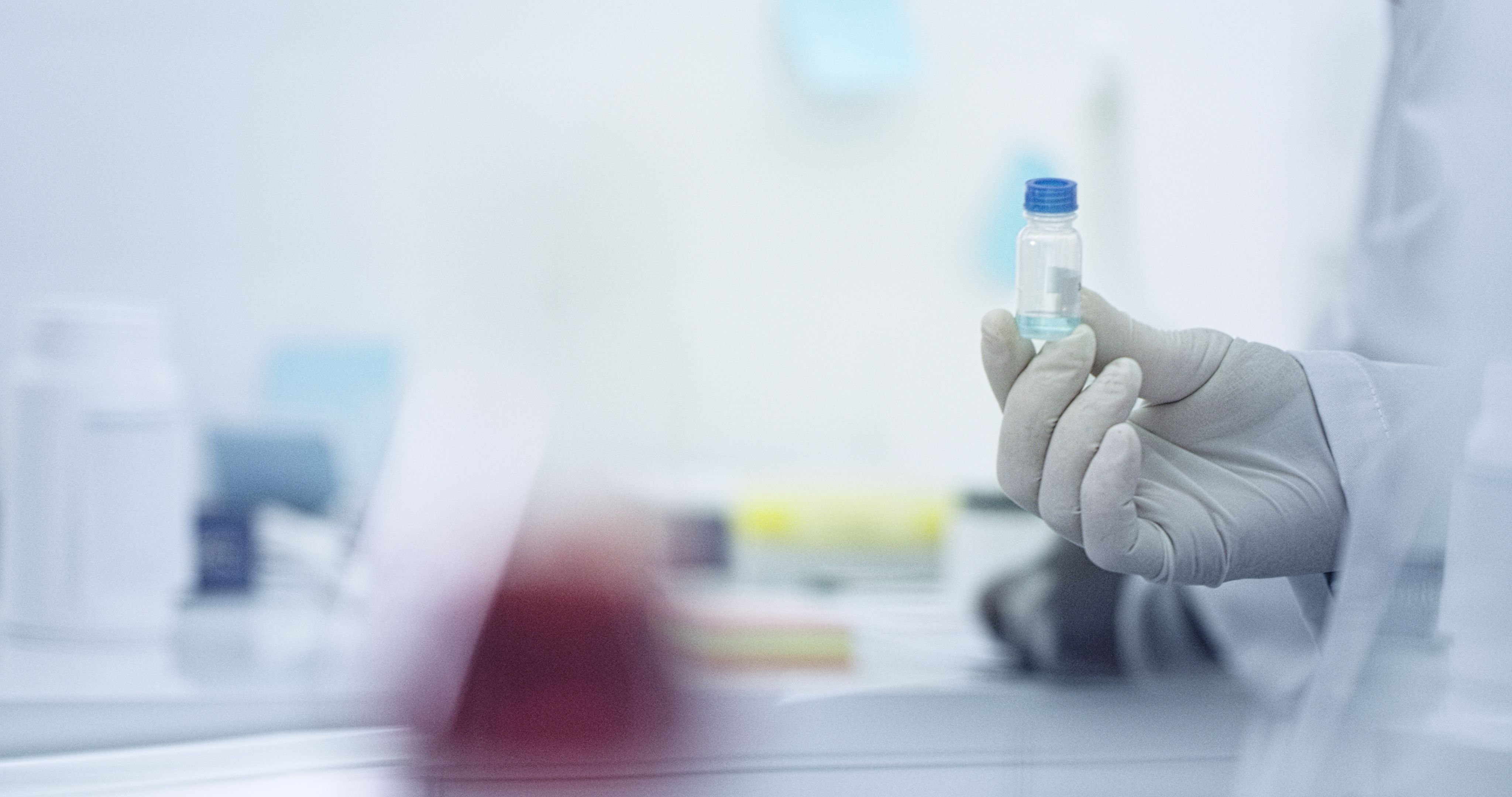 Scientist in laboratorium holds the vial in his hand Scientist in laboratorium holds the vial in his hand