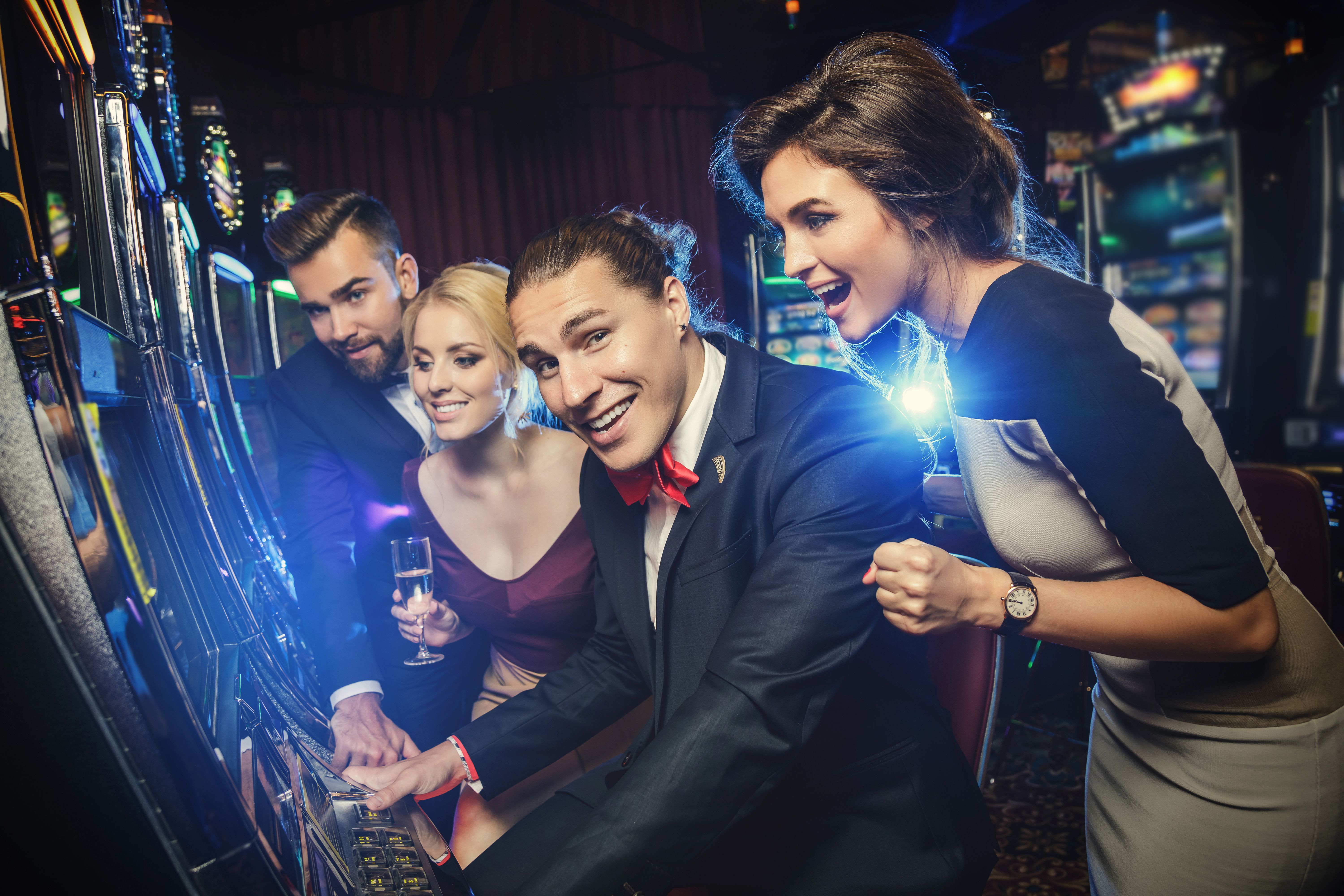 Group of friends playing slot machines Group of friends playing slot machines