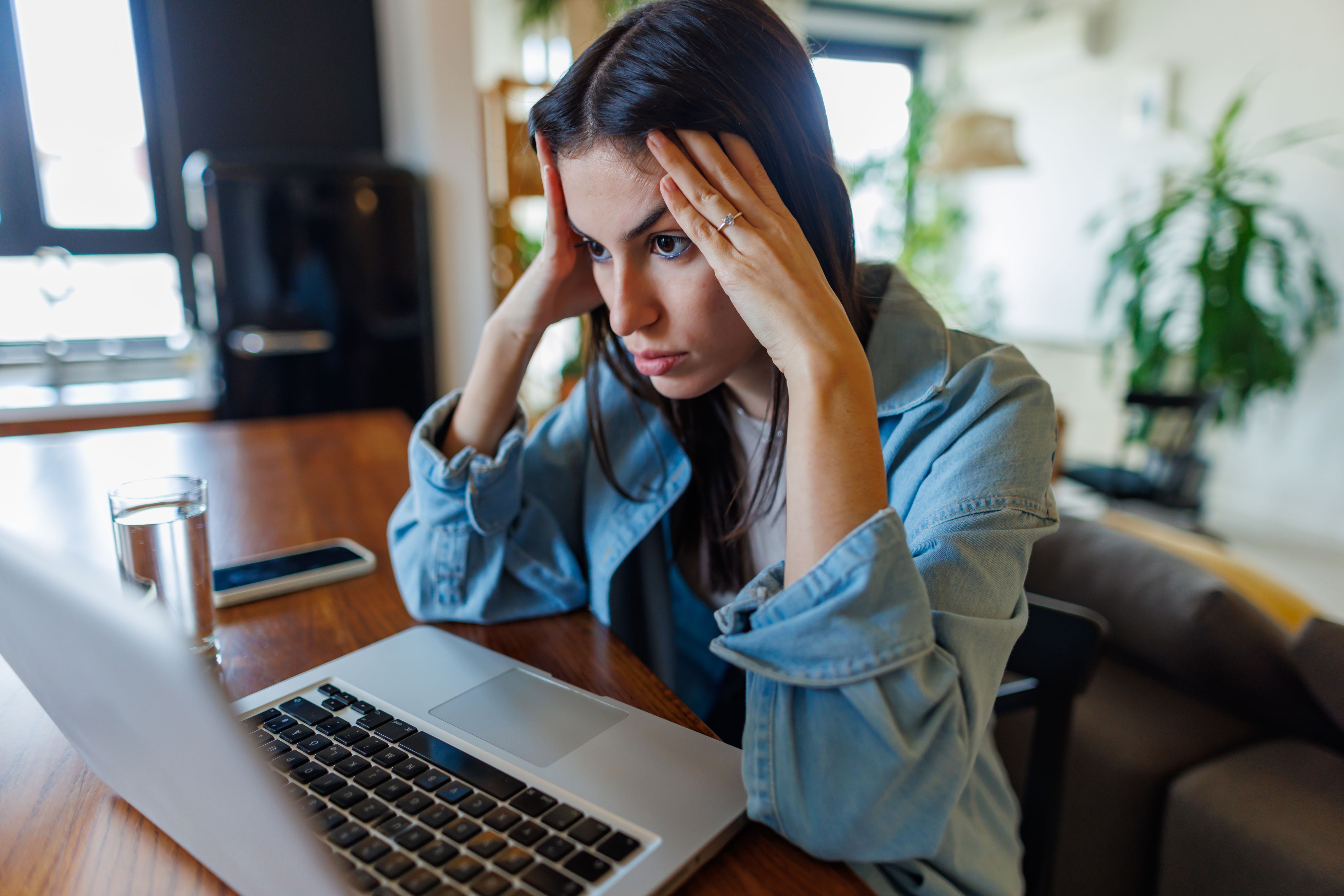 Young Adult Woman Feeling Stressed While Working on Laptop