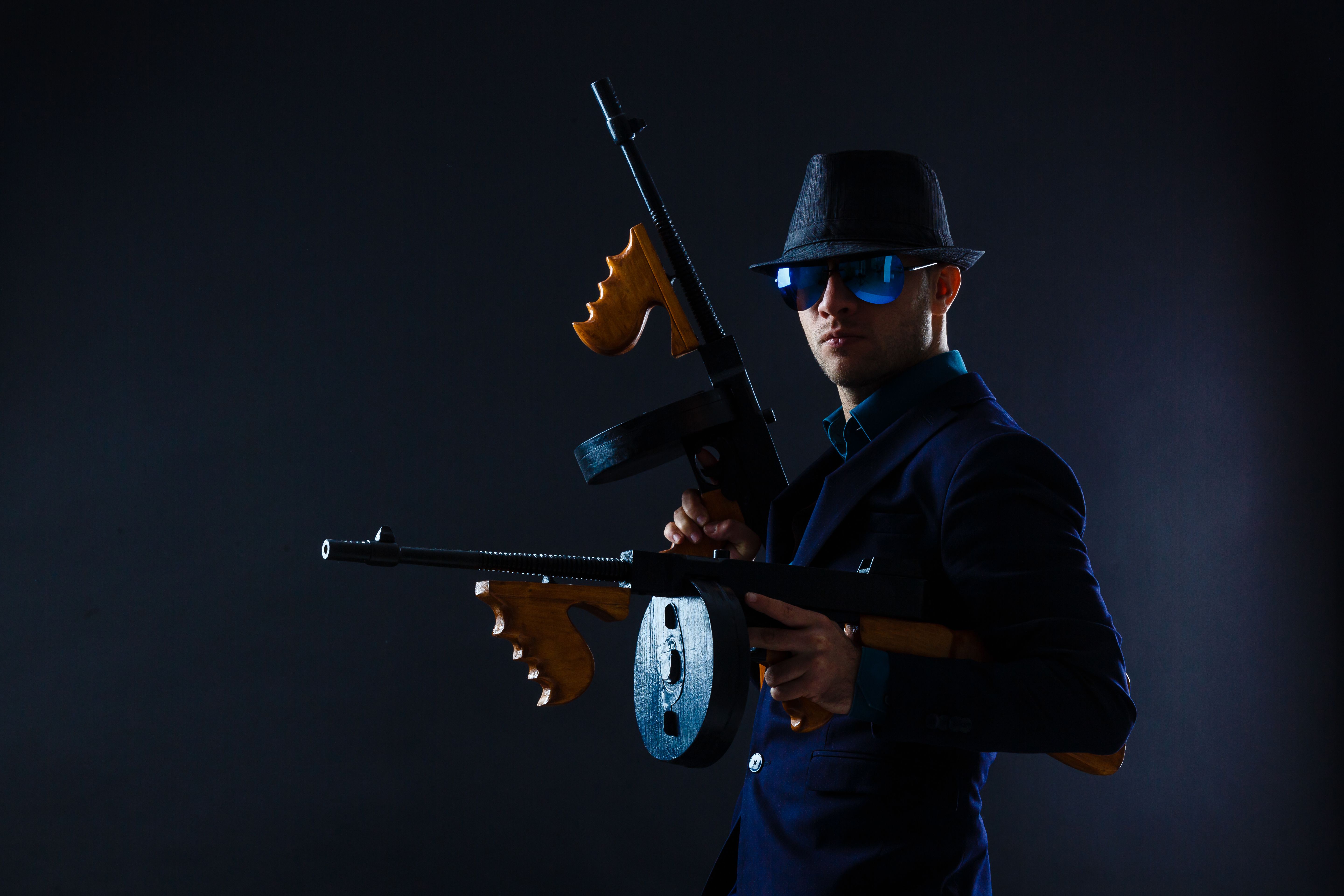 low key portrait of young gangster with hat in the darkness