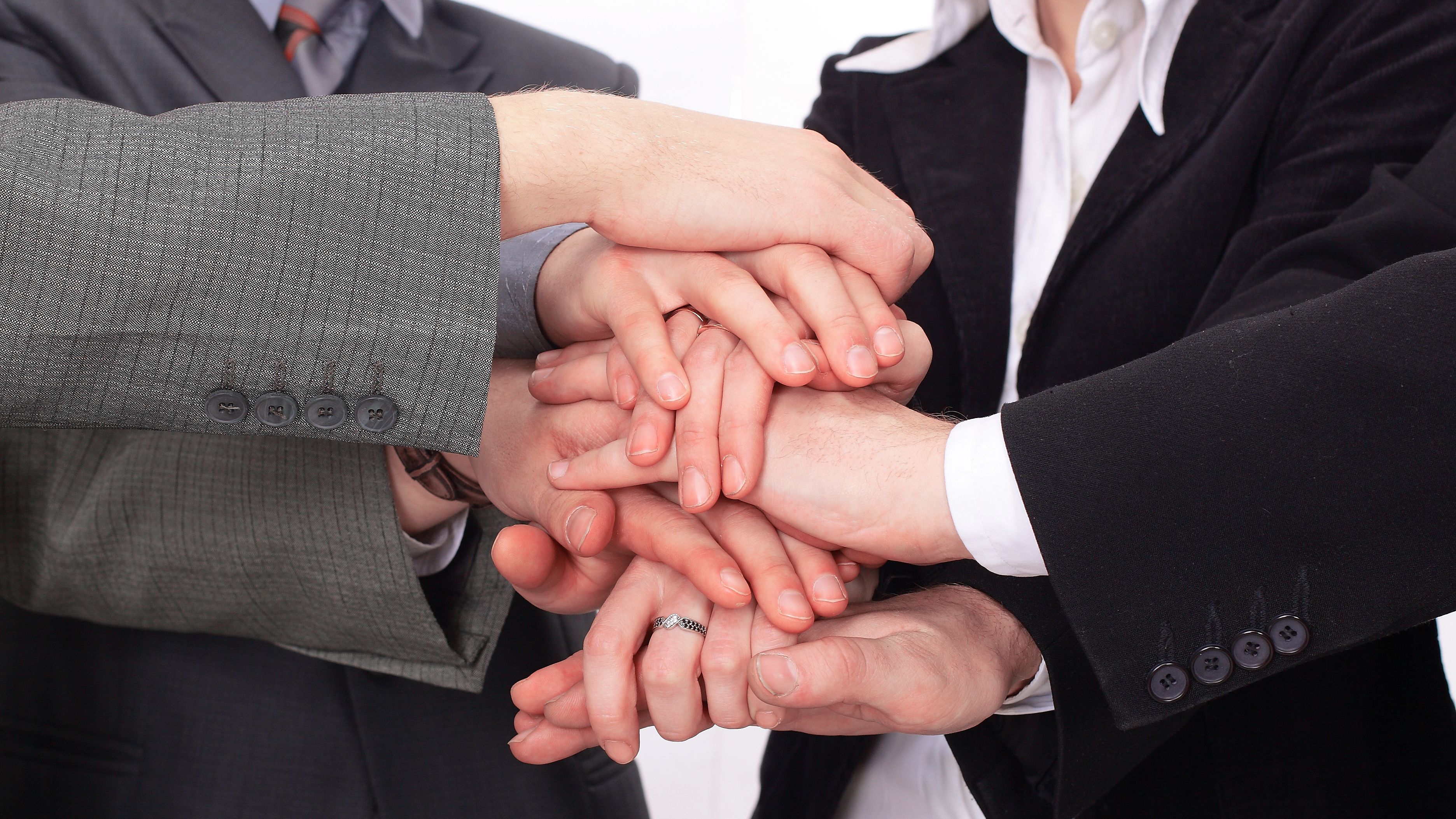 group of business people with hands clasped together.
