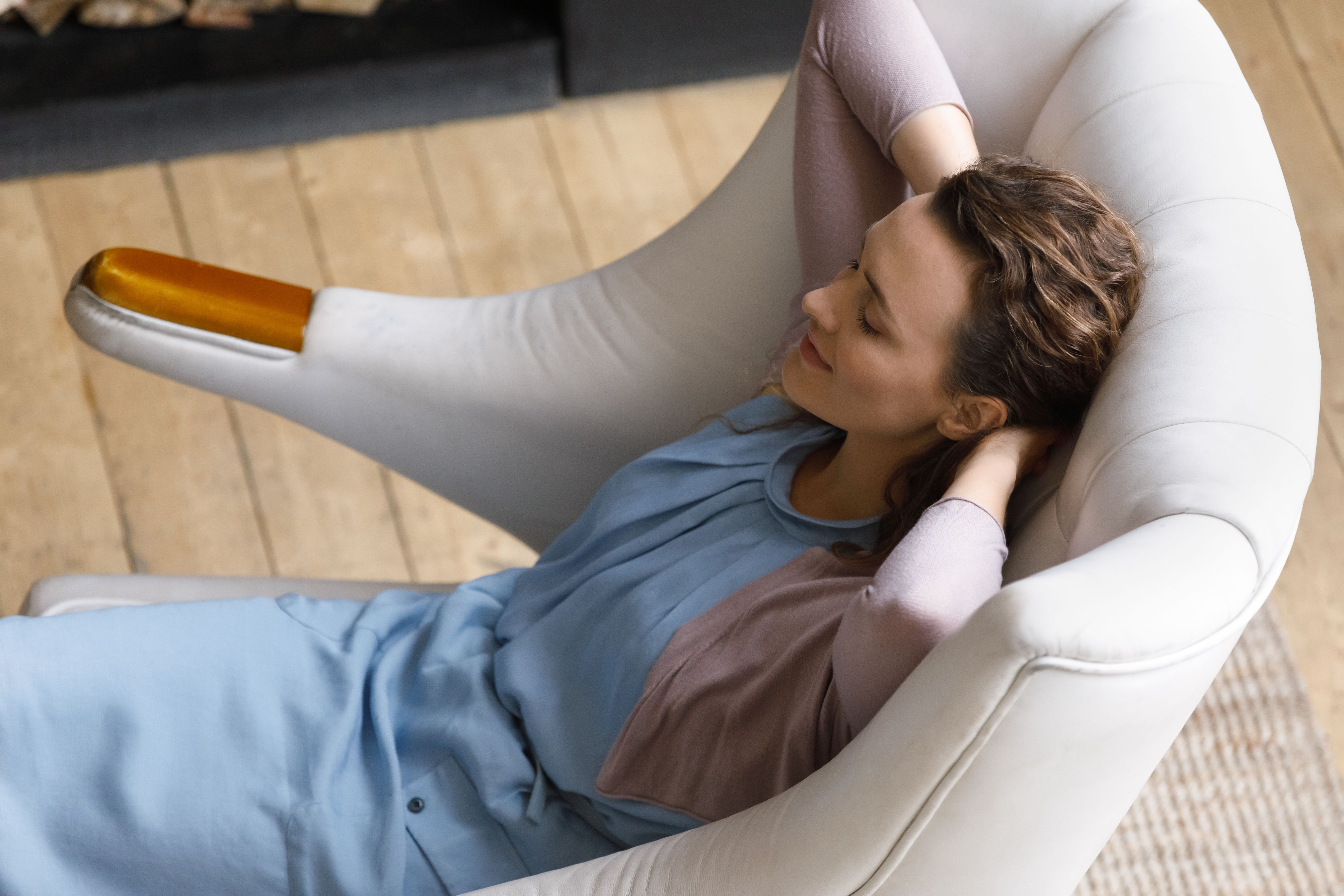 Peaceful satisfied relaxed millennial renter woman resting in soft armchair