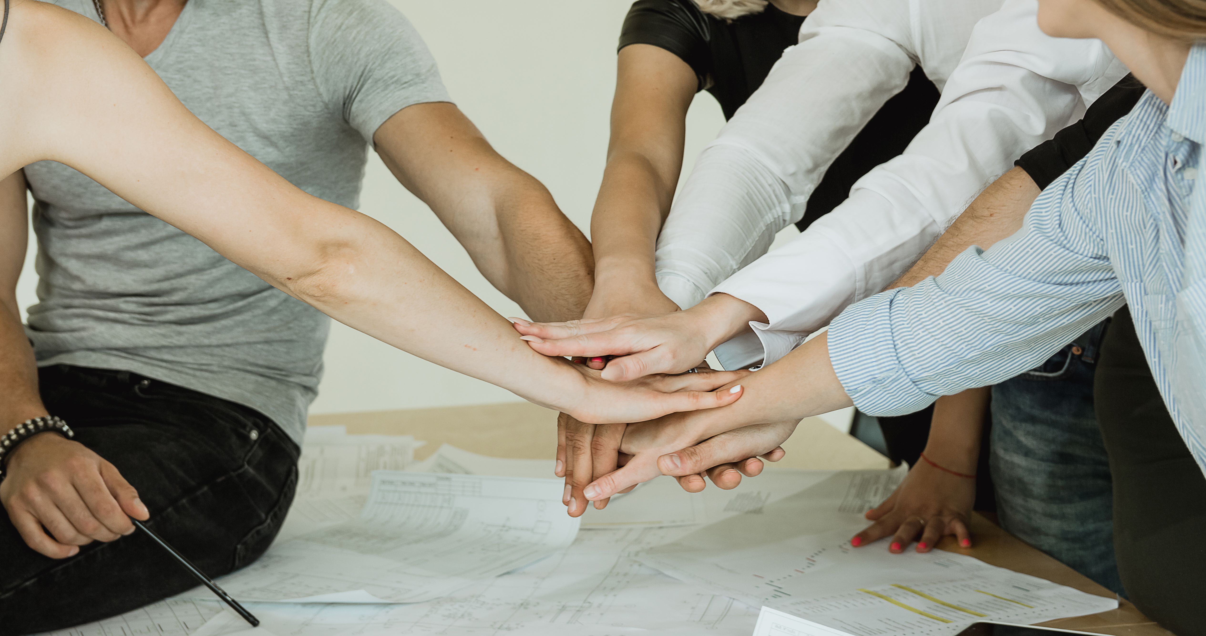 many fists of a group of people showing connection with sky in the back many fists of a group of people showing connection with sky in the back