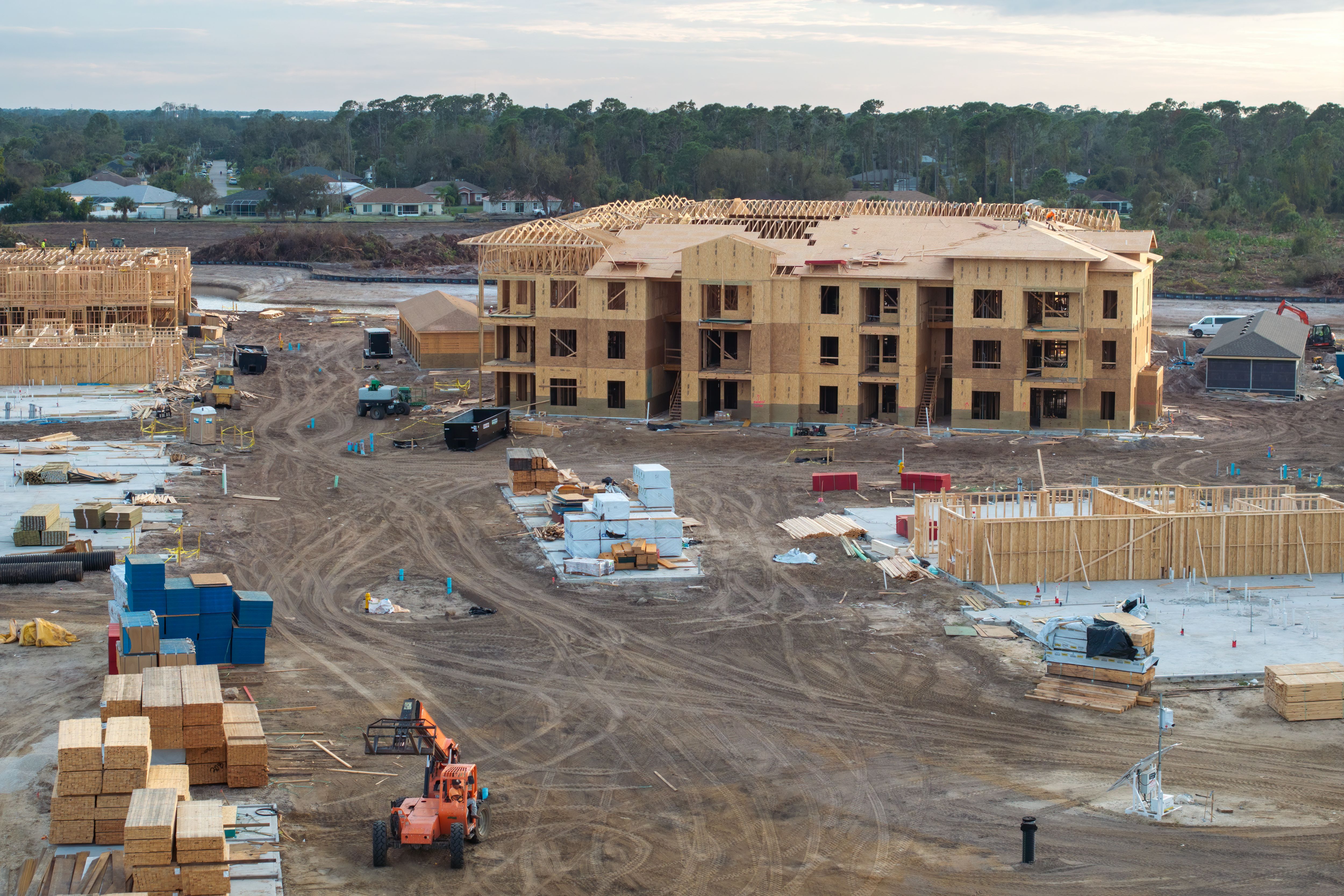 Wooden apartment buildings under construction in new developing suburban area. Development of residential housing in Florida suburbs. Real estate market in the USA Wooden apartment buildings under construction in new developing suburban area. Development of residential housing in Florida suburbs. Real estate market in the USA
