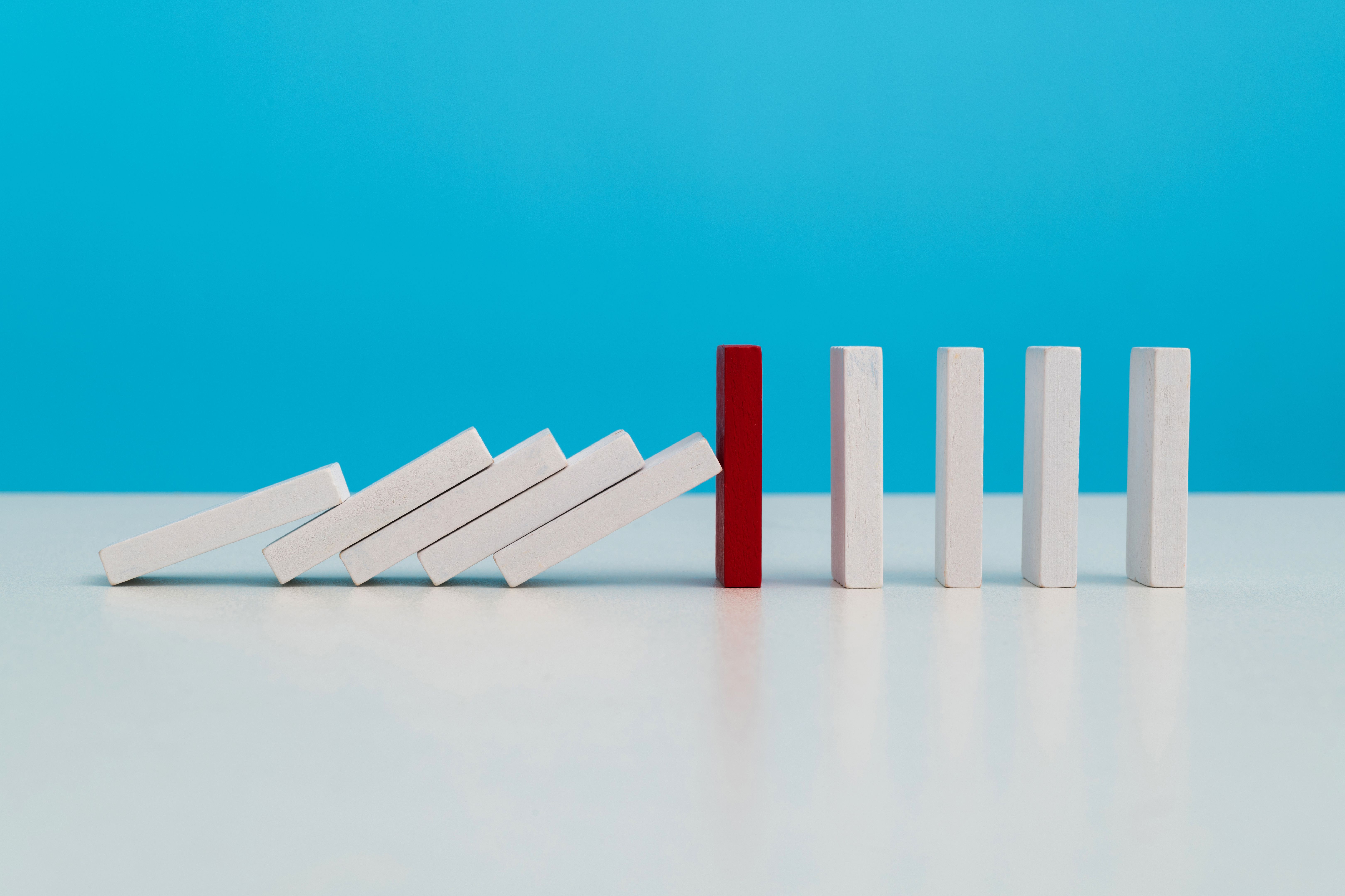 Red wooden block stop other falling dominos Red wooden block stop other falling dominos