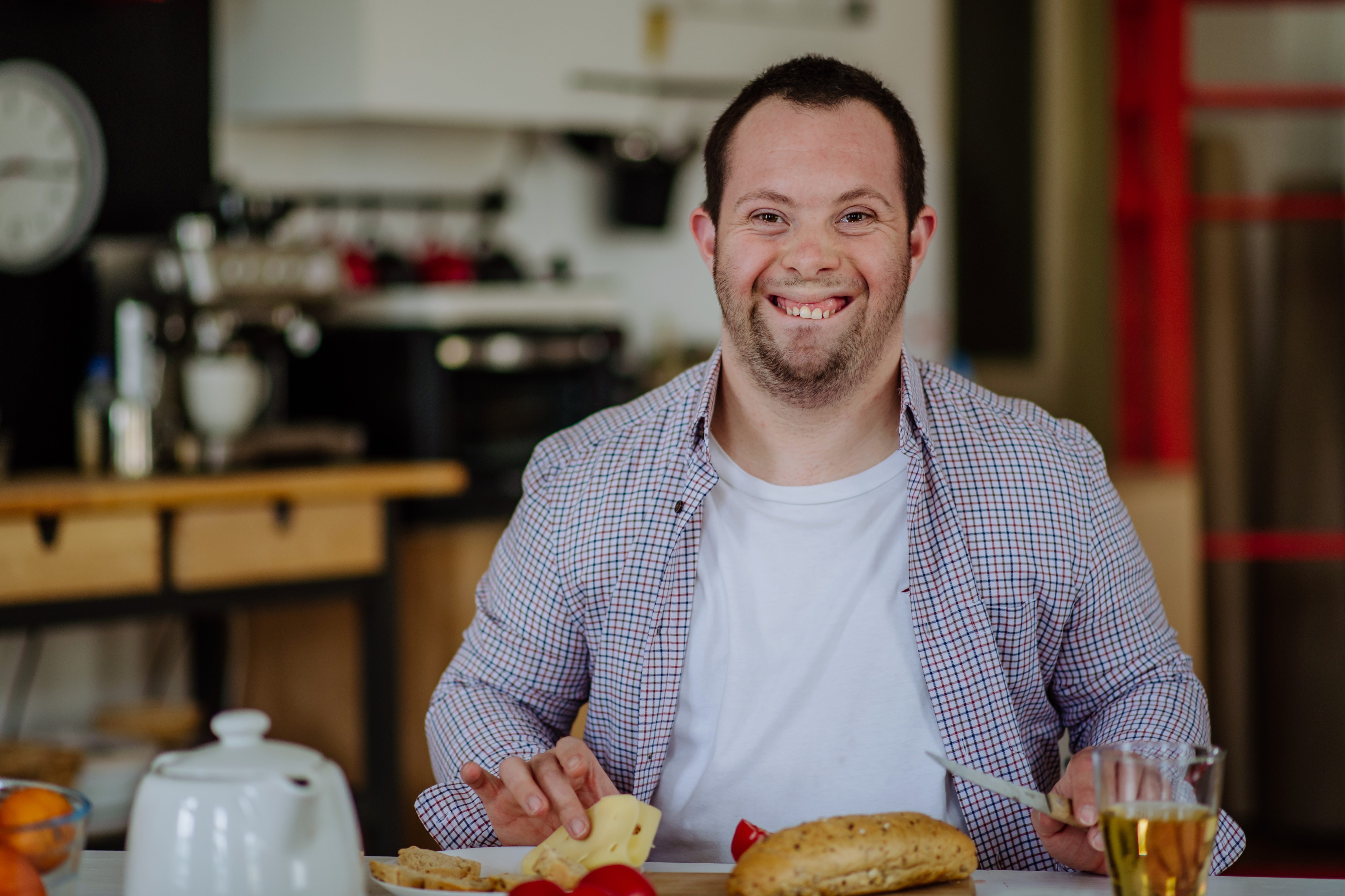 Independent man with down syndrome preparing brekfast in his apartment.