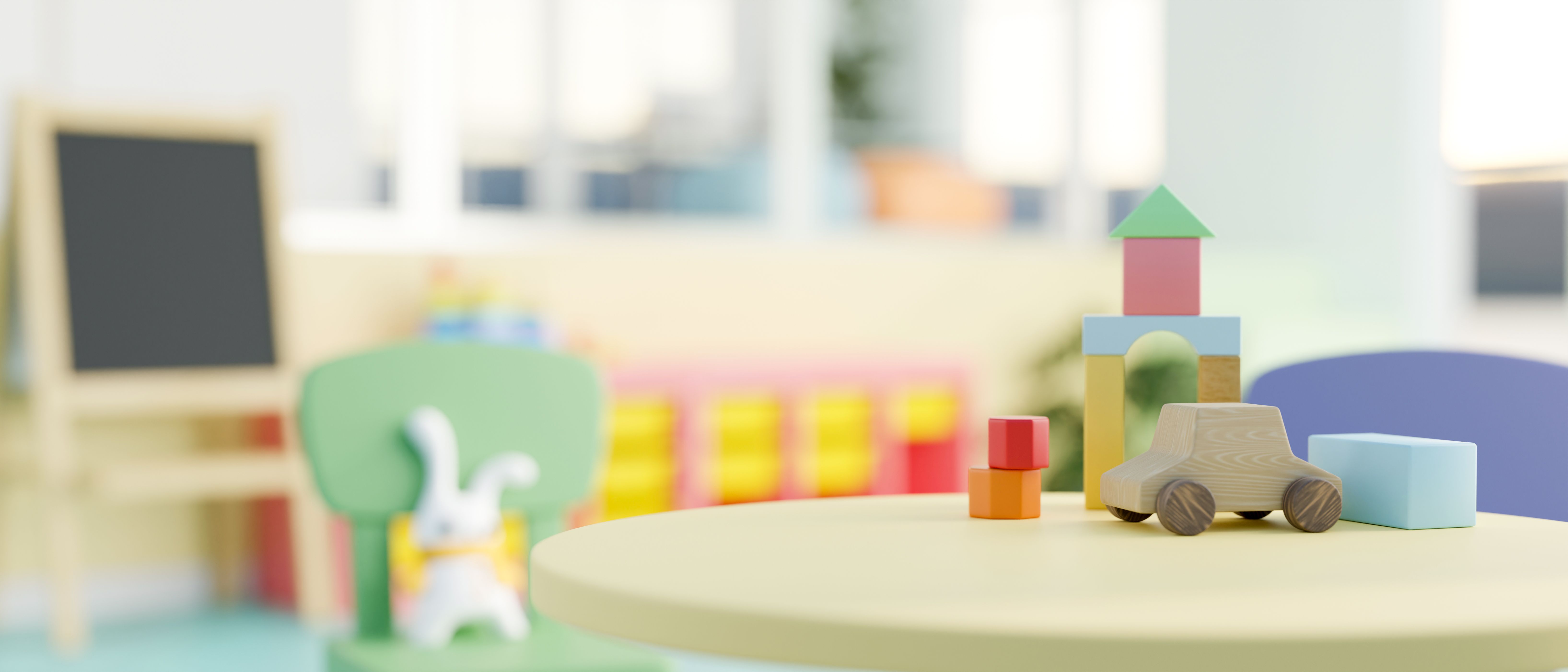 Un'immagine ravvicinata di un tavolo rotondo verde presenta giocattoli per bambini in una colorata classe di scuola materna.