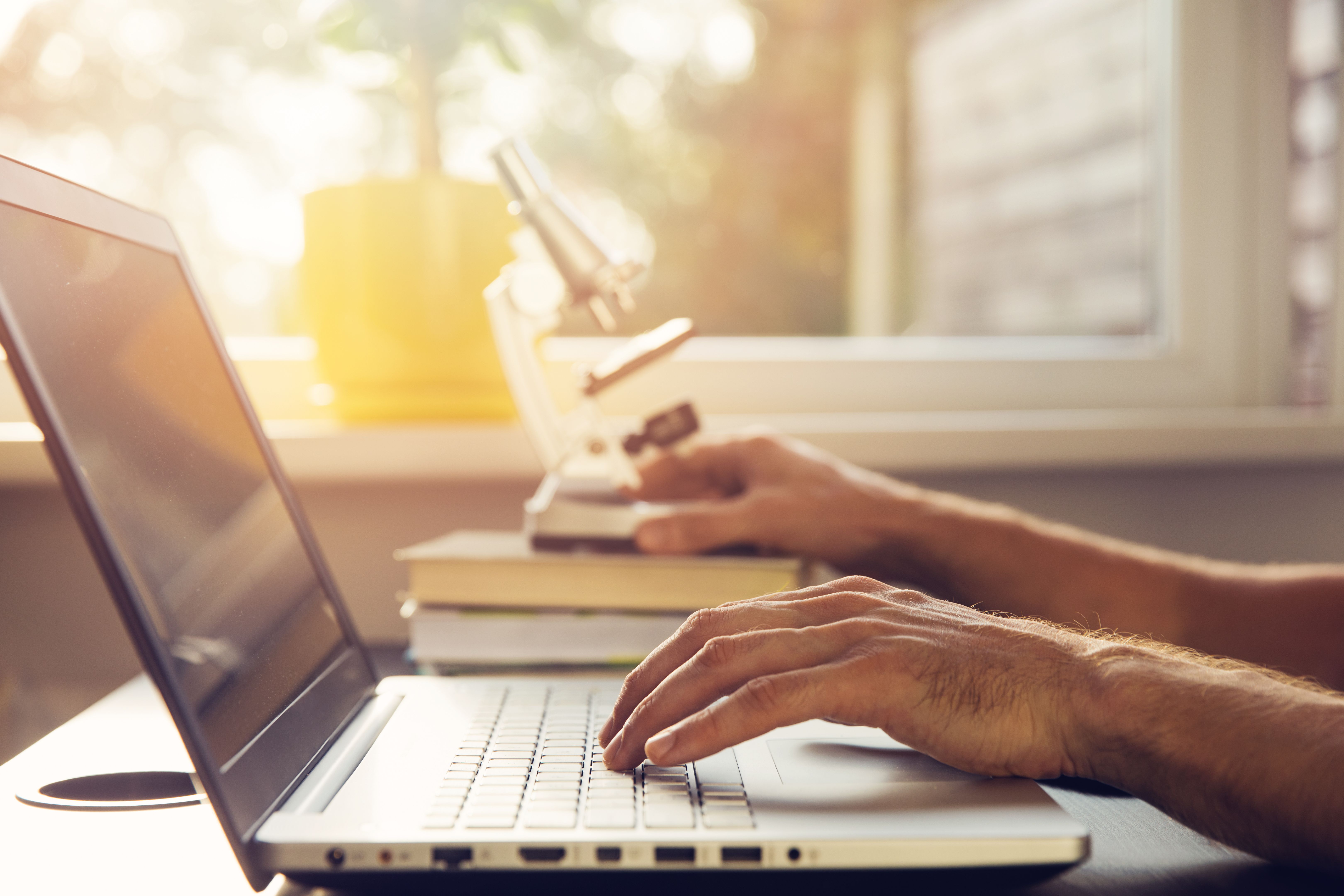 science education - new scientist working with laptop and microscope science education - new scientist working with laptop and microscope