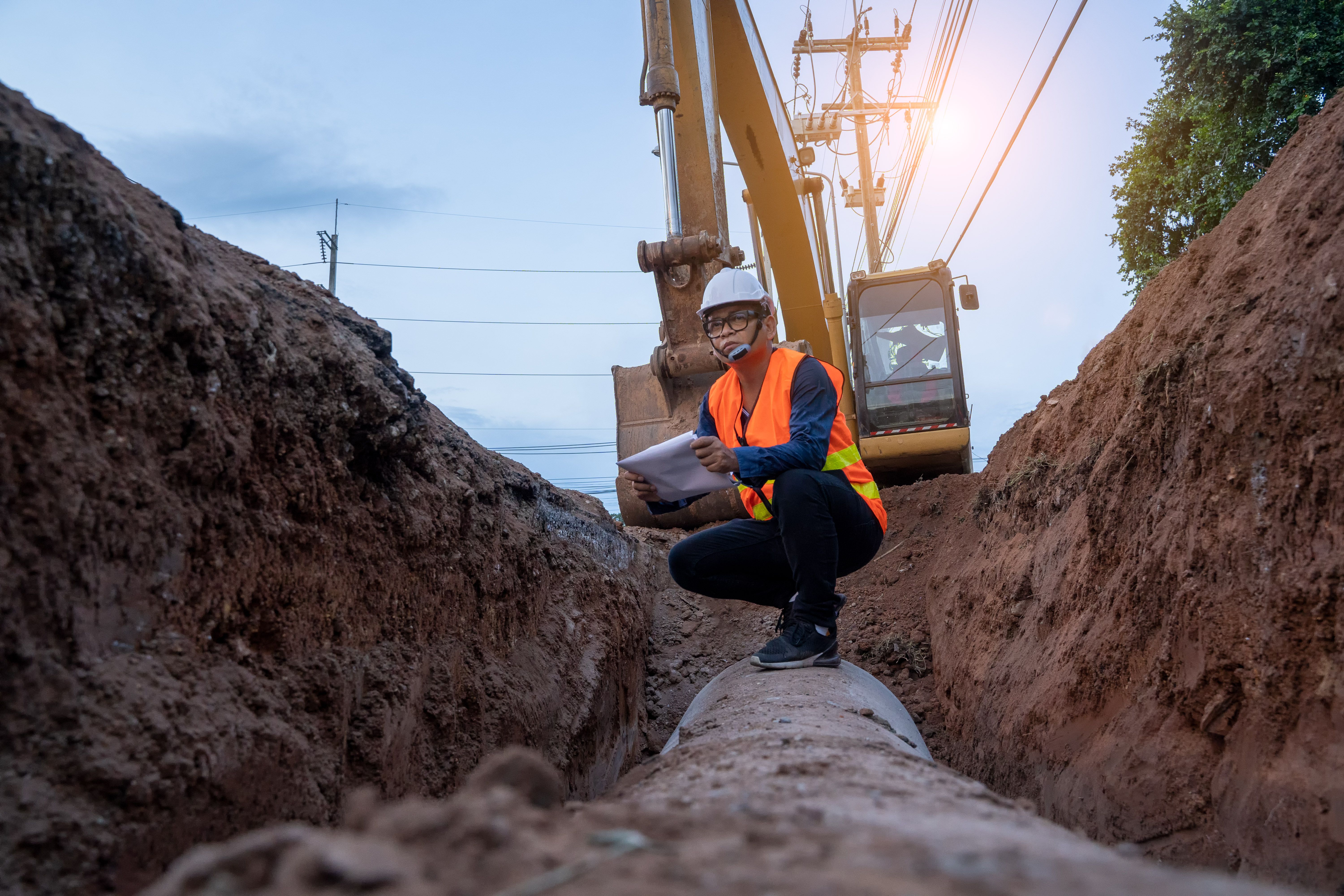 Engineer wear safety uniform examining excavation water supply or sewer pipeline