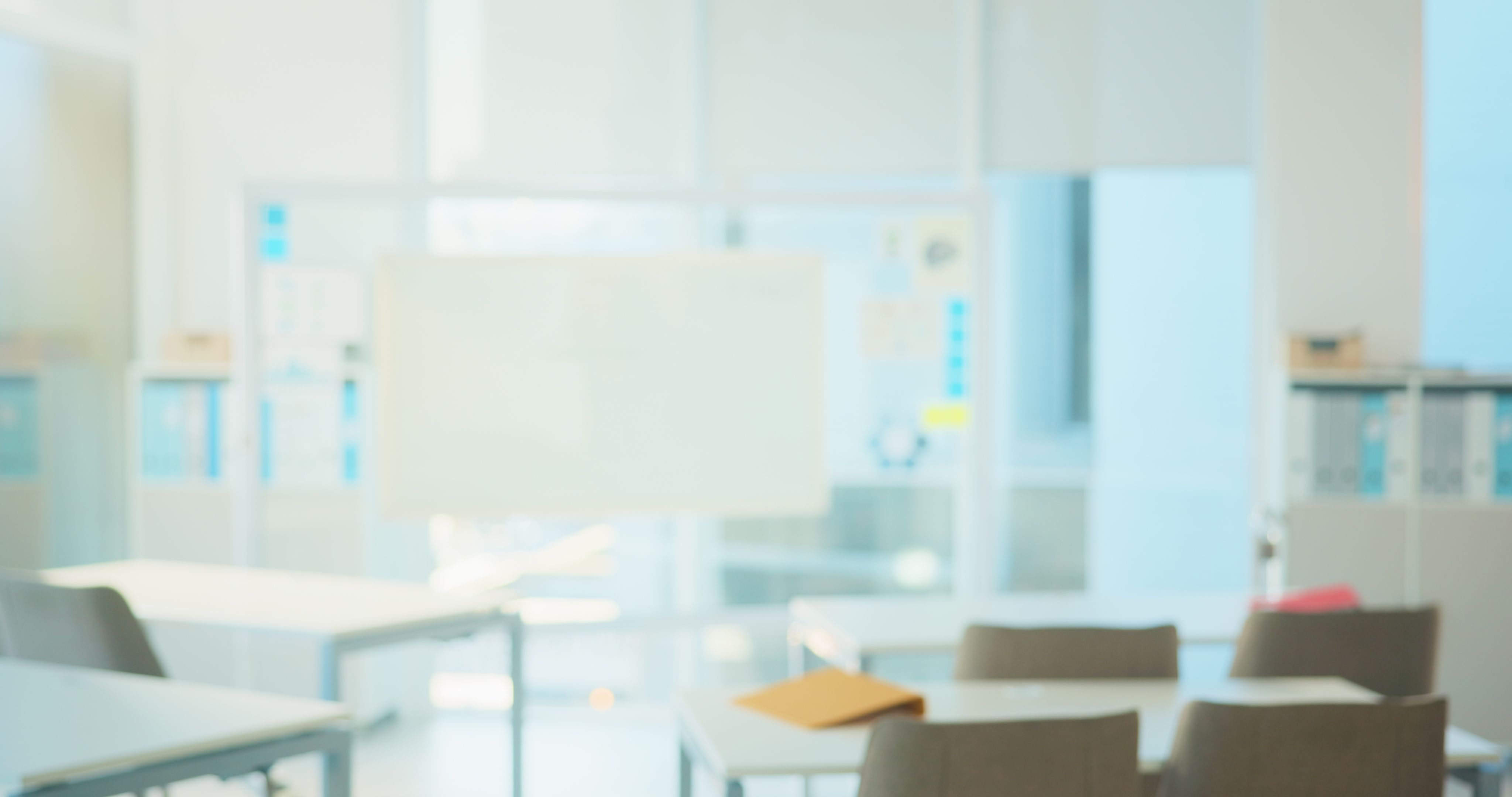 Empty classroom, desk and chairs for learning at college with lens flare, board and table in hall. Blurred room, campus and furniture at venue for scholarship, development and interior at university