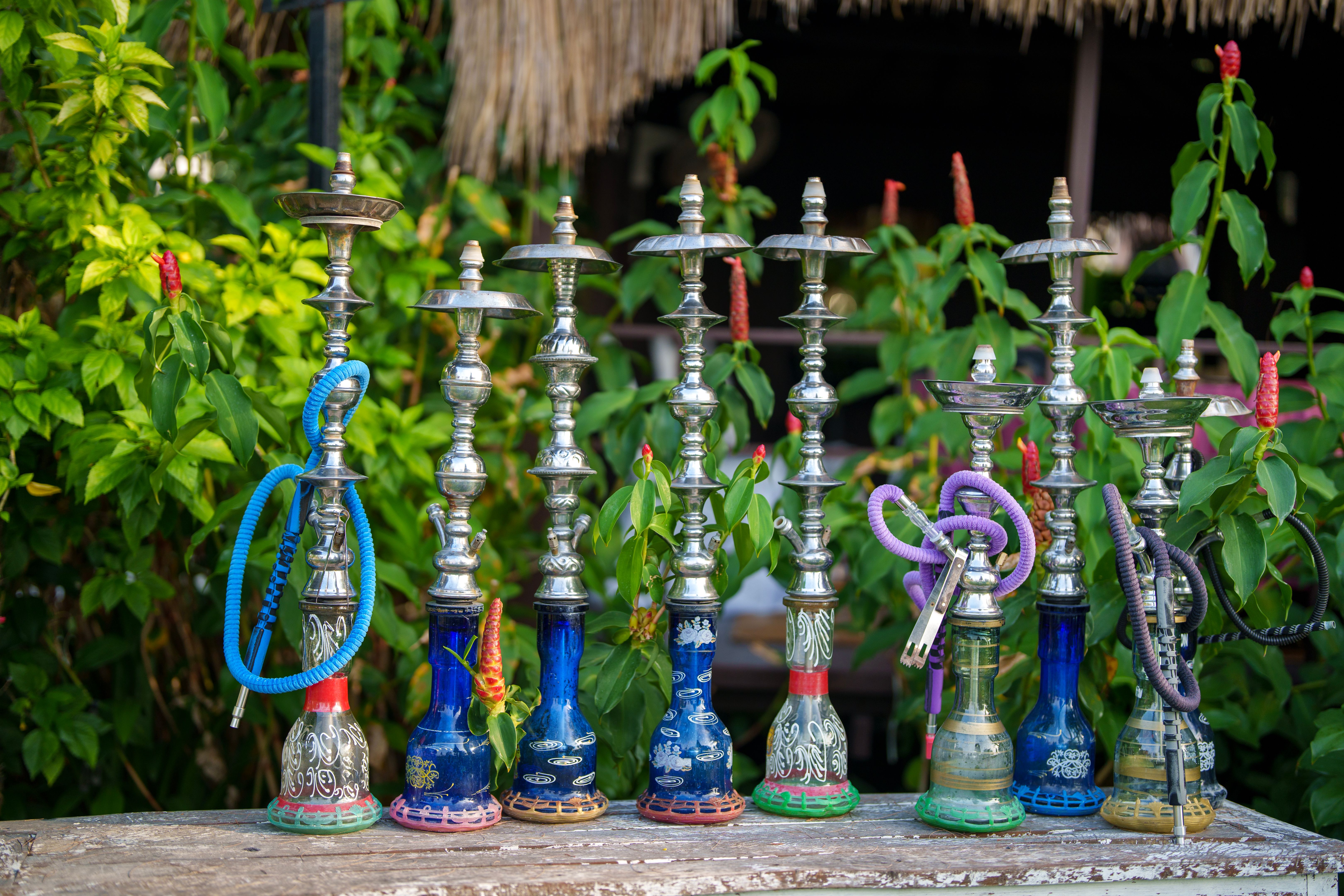 Colorful Shisha water pipes displayed in a row on wood counter