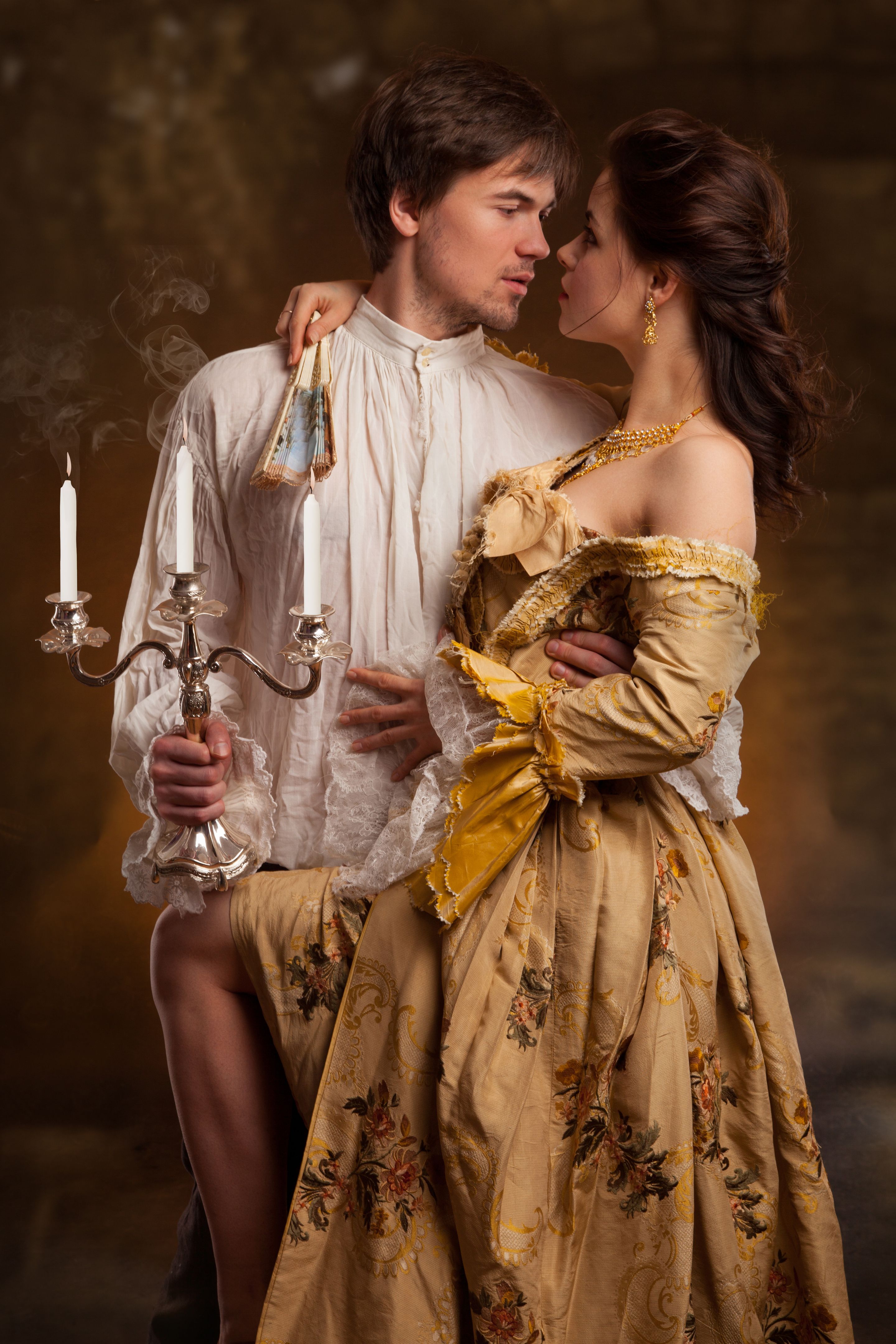 portrait of couple in historical costumes on dark background