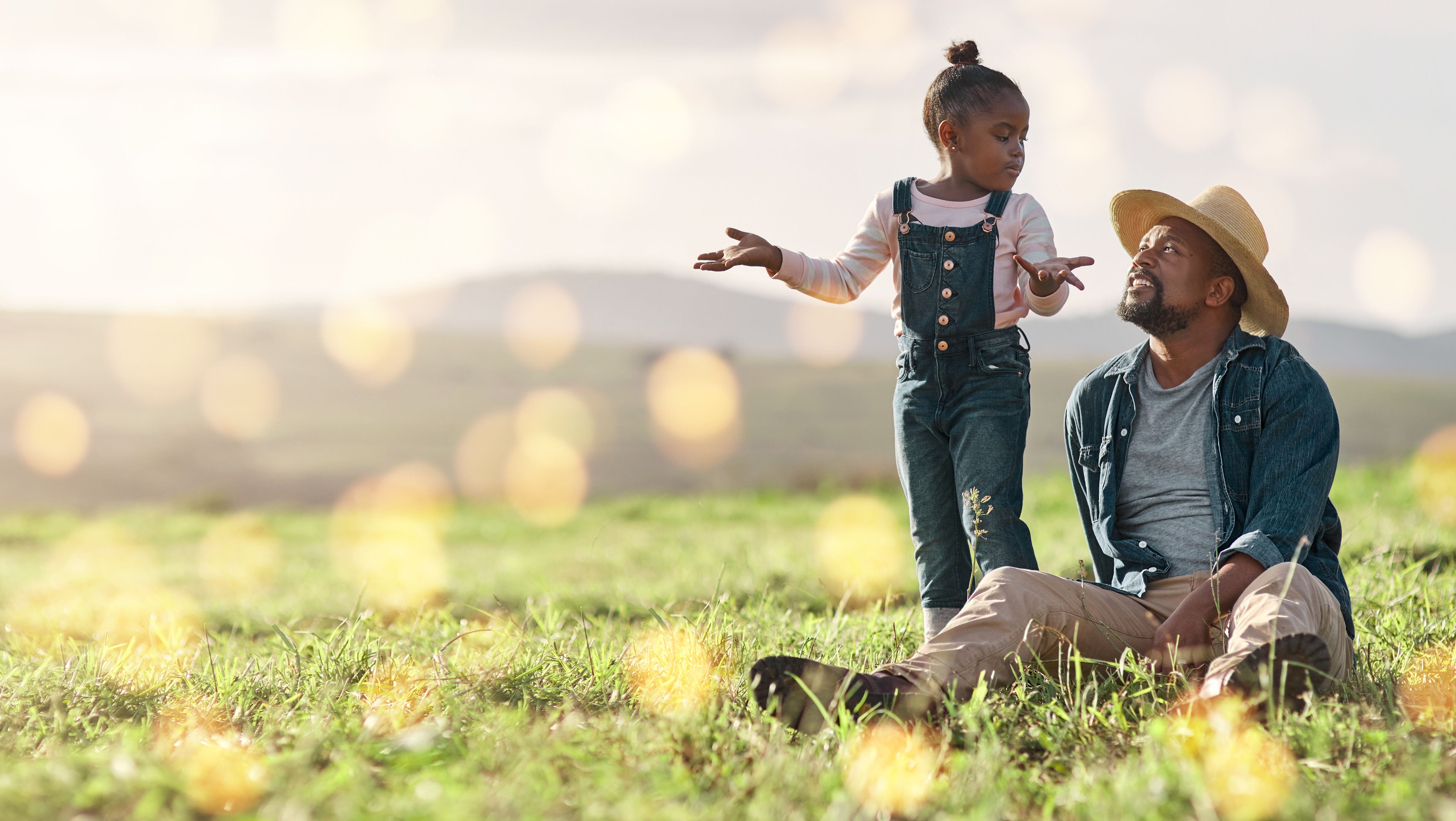 Bonding, relax and father and child on a field for playing, adventure and conversation in nature. Agriculture, communication and African dad talking to a playful girl on the grass in the countryside