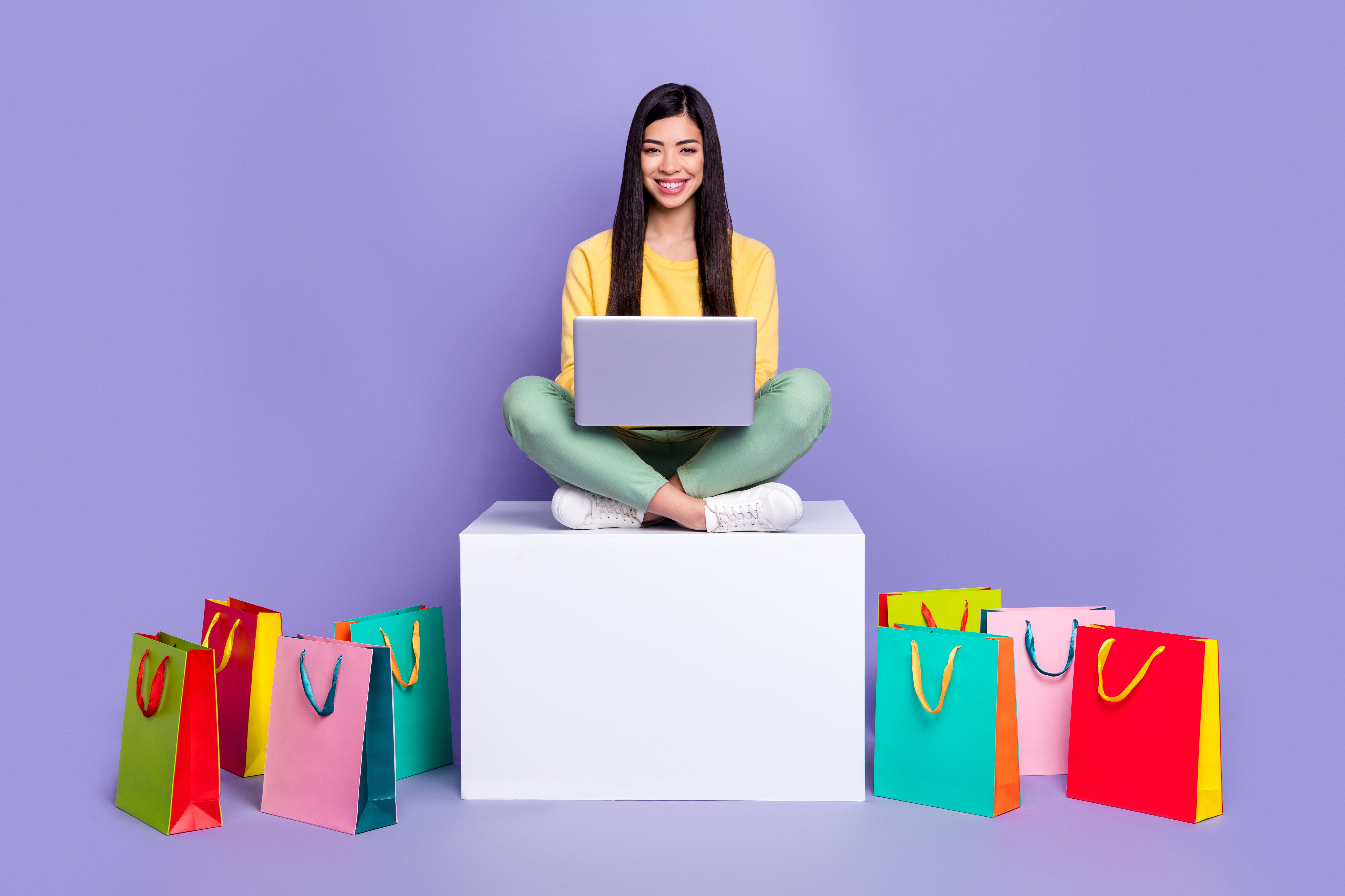 Full size photo of young girl sit podium use laptop shop boutique new collection isolated over violet color background