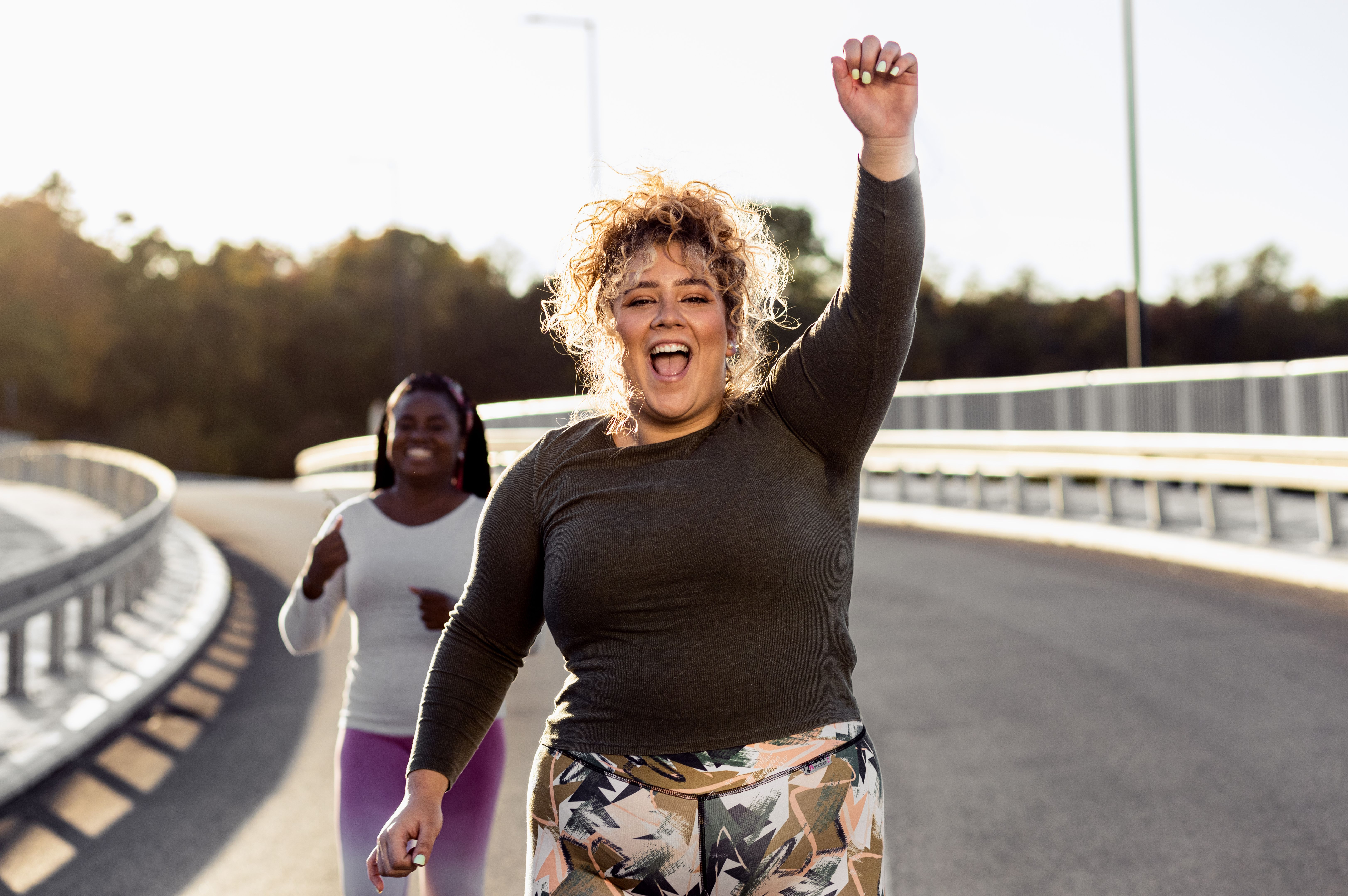 Two young plus size women jogging together.