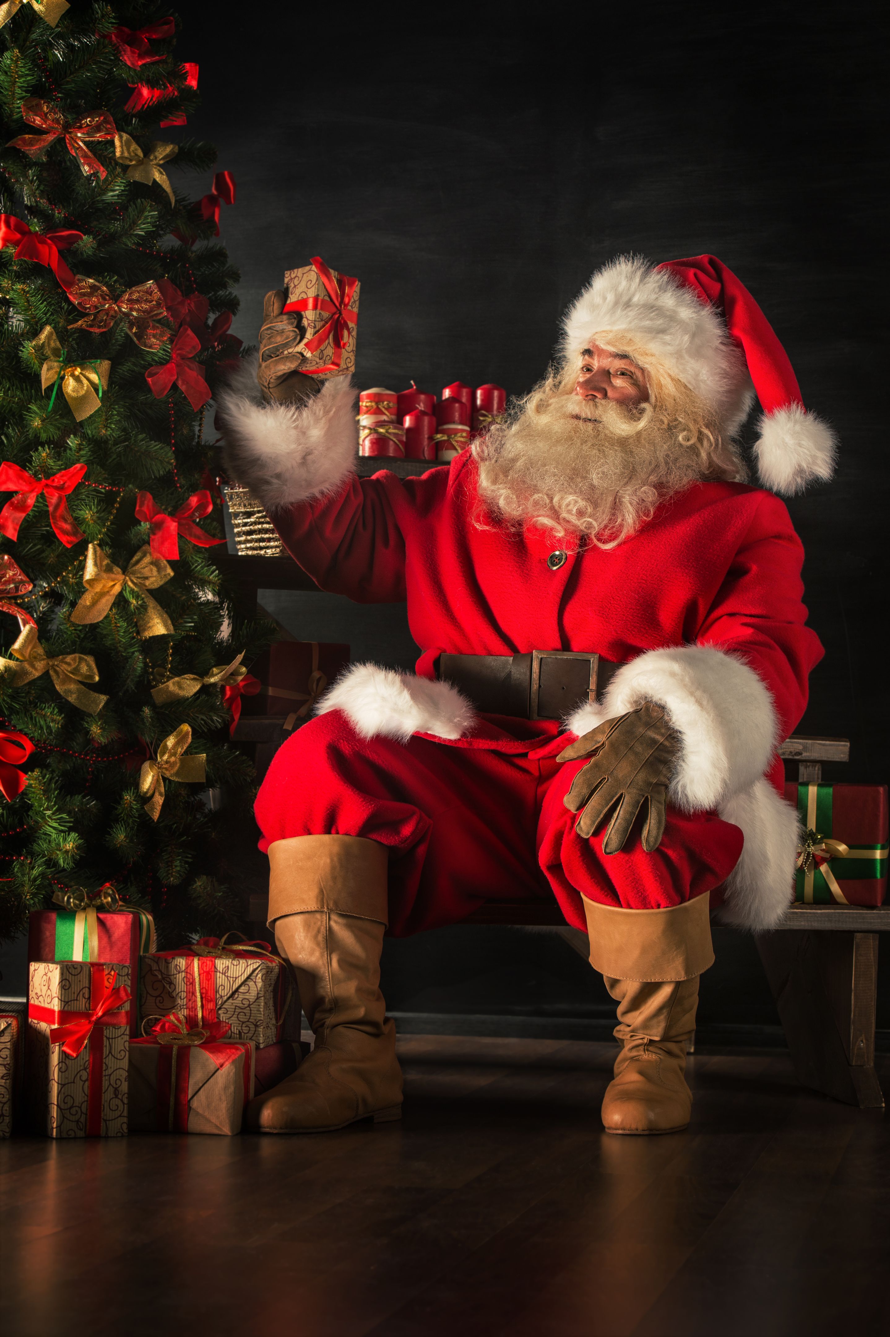 Santa is placing gift boxes under Christmas tree