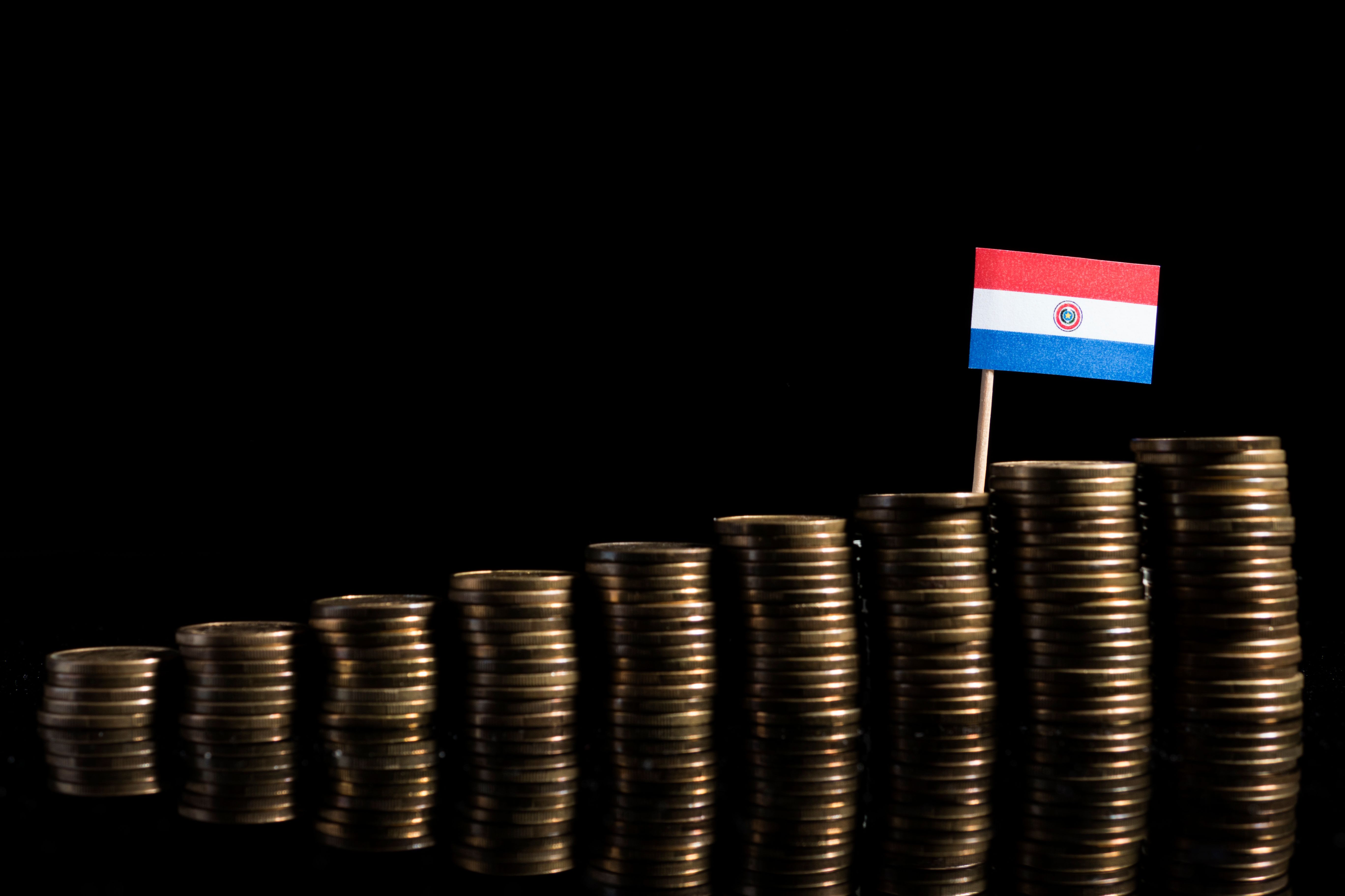 Bandeira do Paraguai com um monte de moedas isoladas no fundo preto