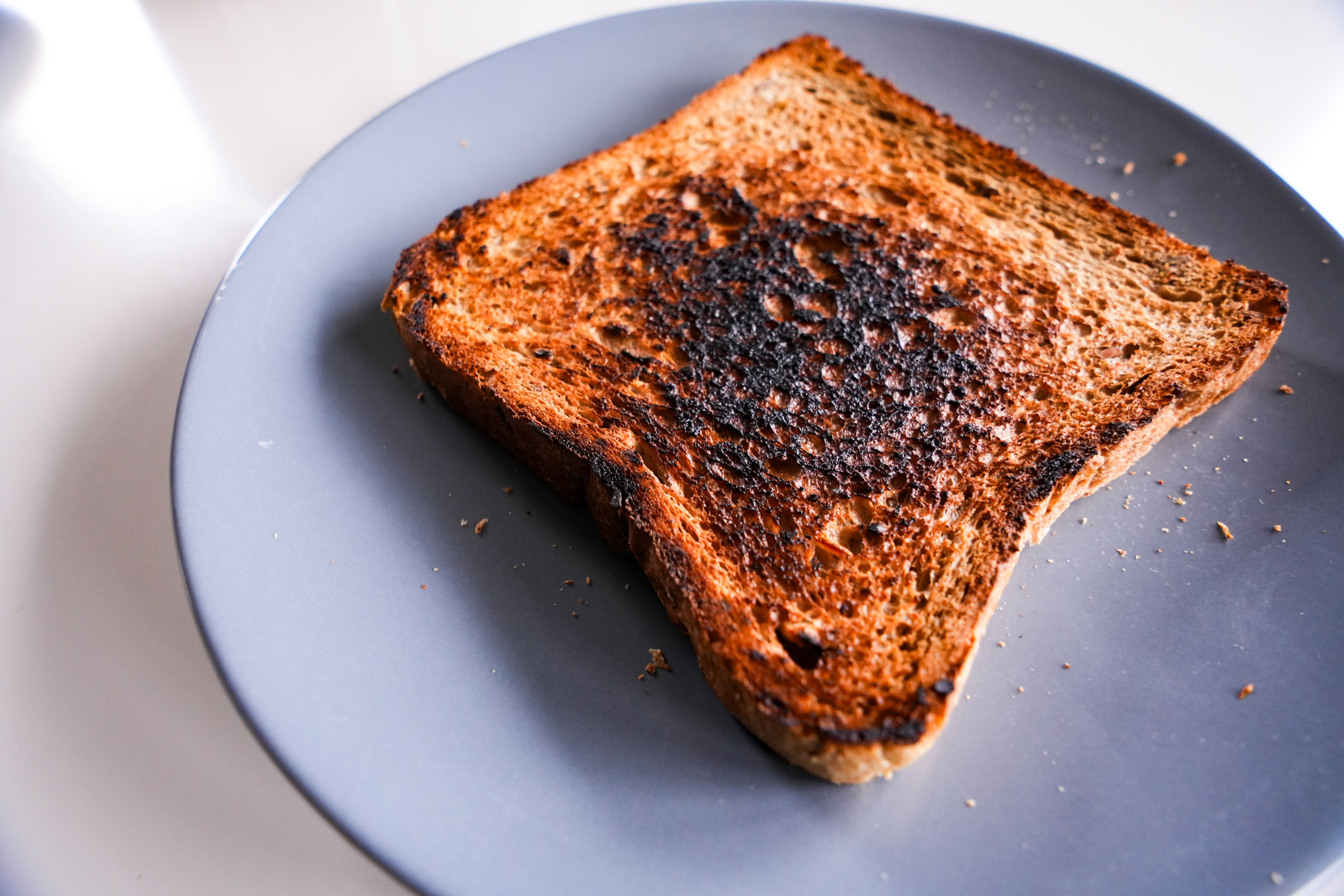 Burnt slice of toast bread isolated on white with text space