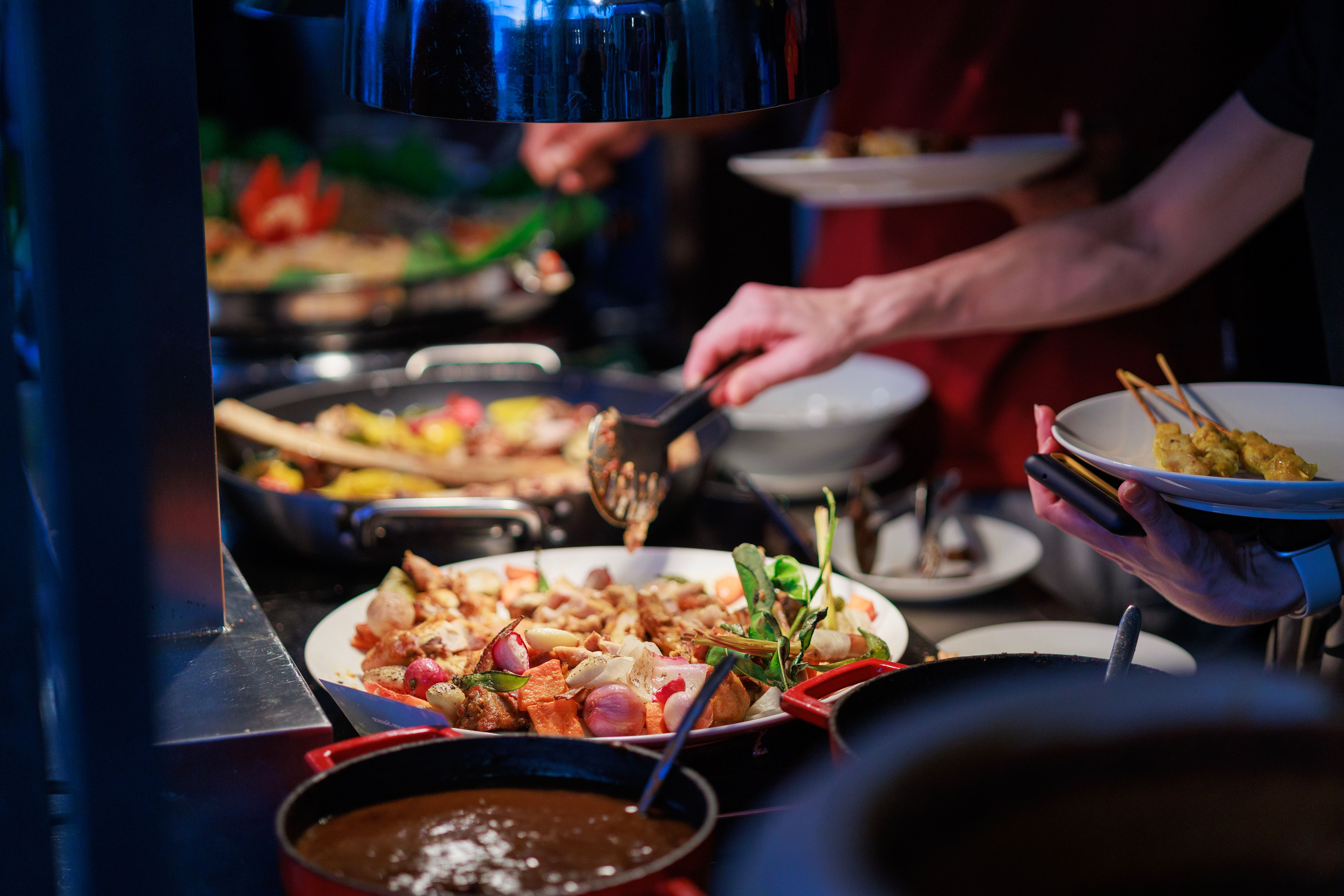 Close-up of people picking up food from the buffet line Close-up of people picking up food from the buffet line