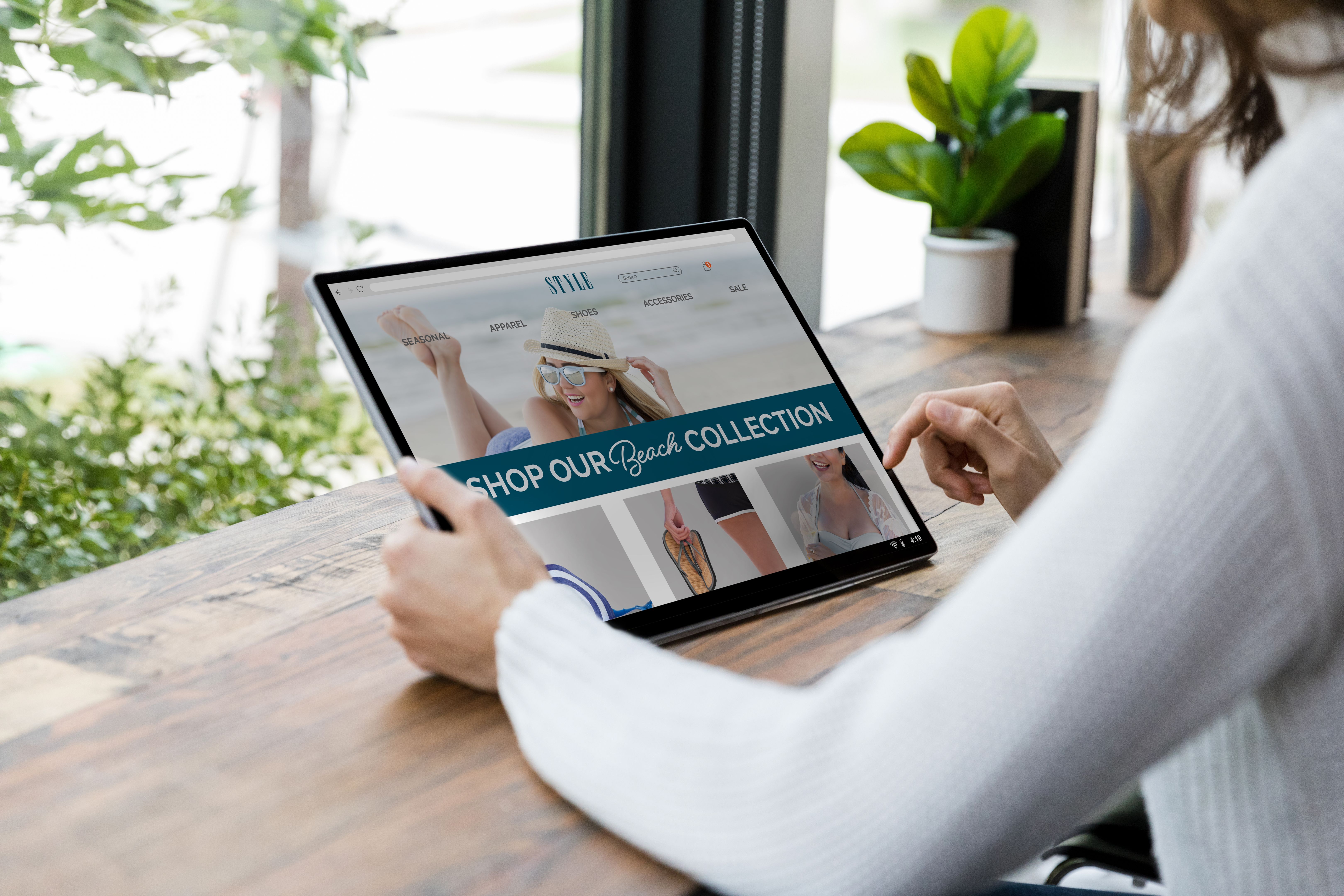 Unrecognizable woman searches site on tablet for summer wear