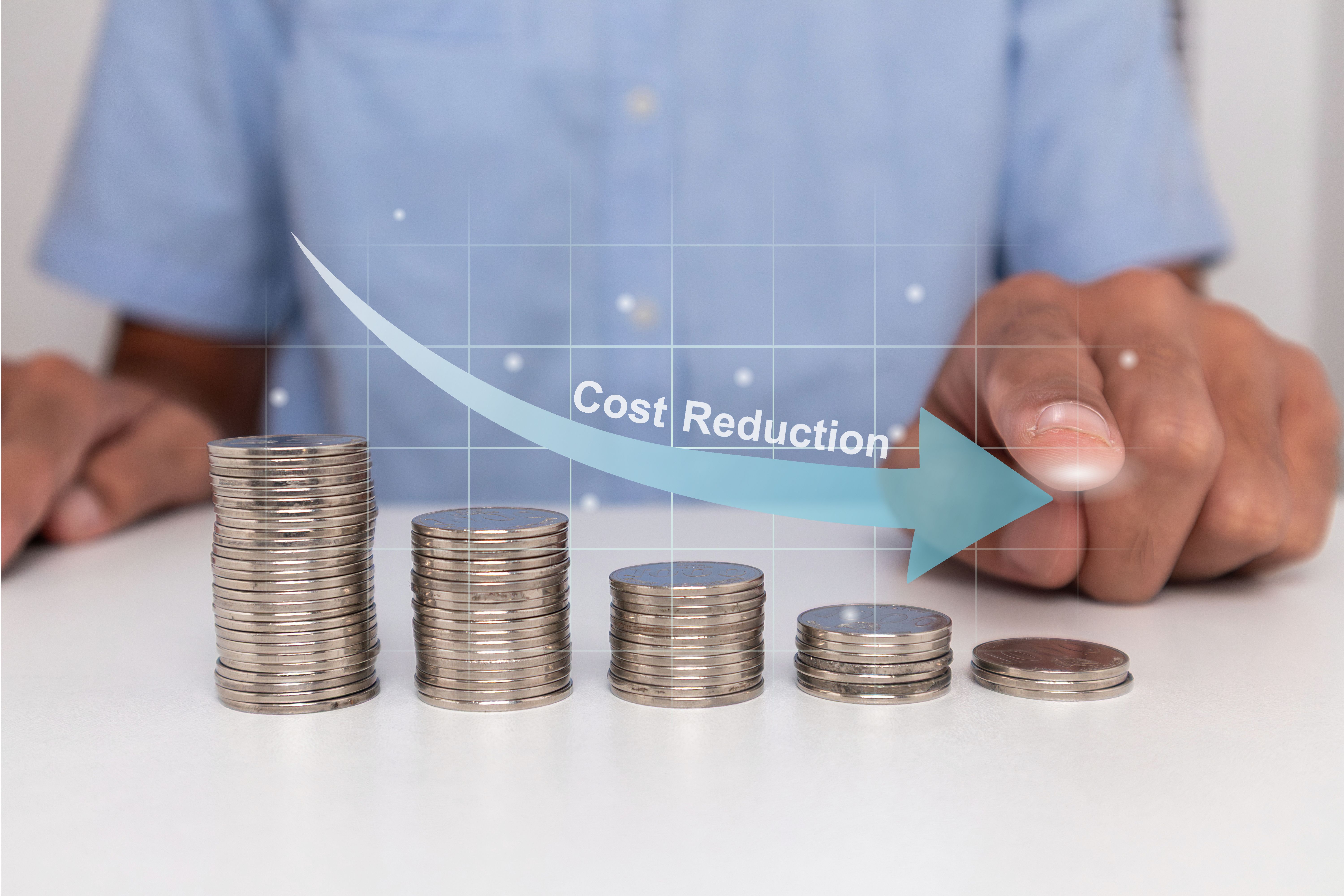 Stack of coins in descending order with down arrow. Cost reduction concept.