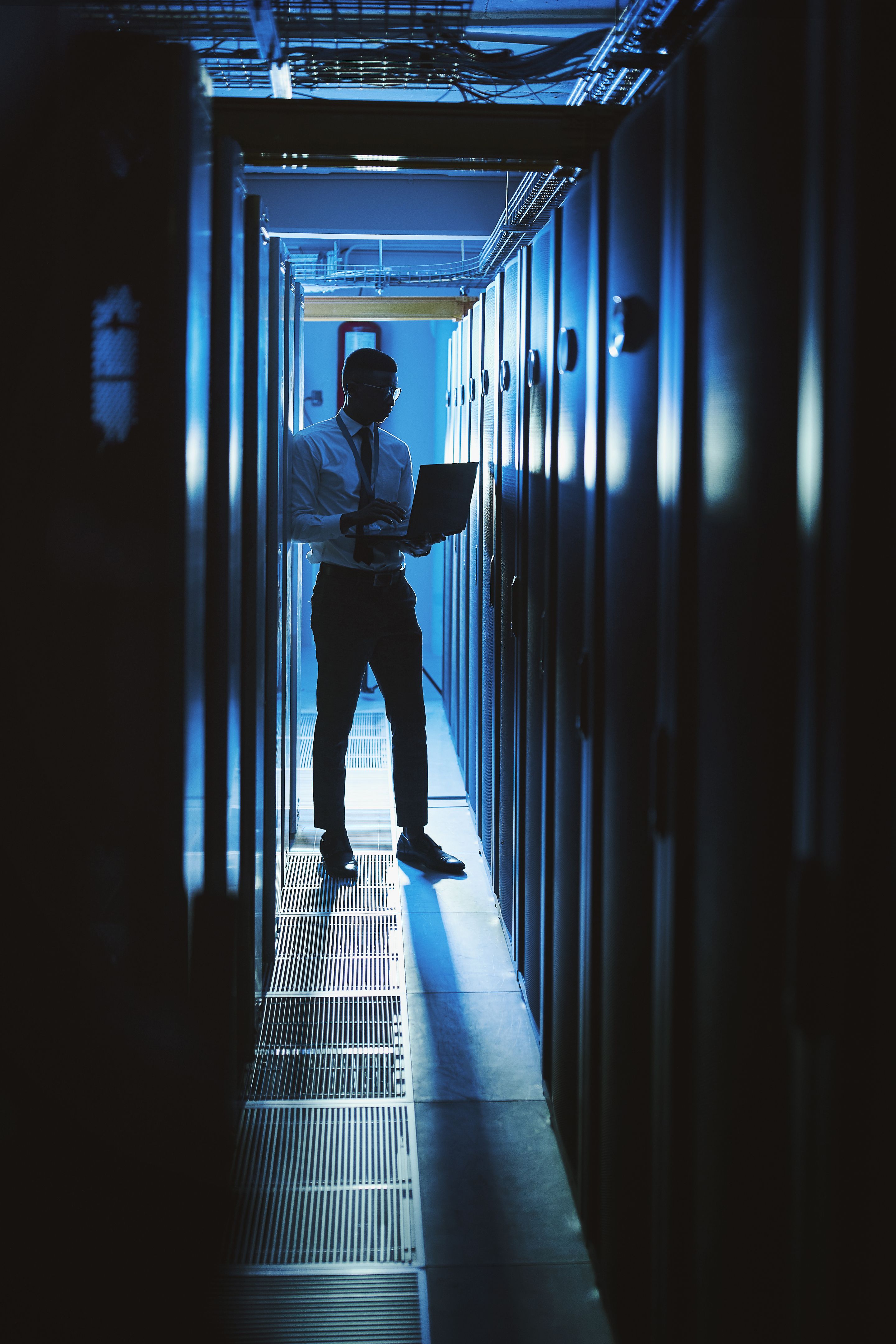 Shot of a young man working in an IT server room