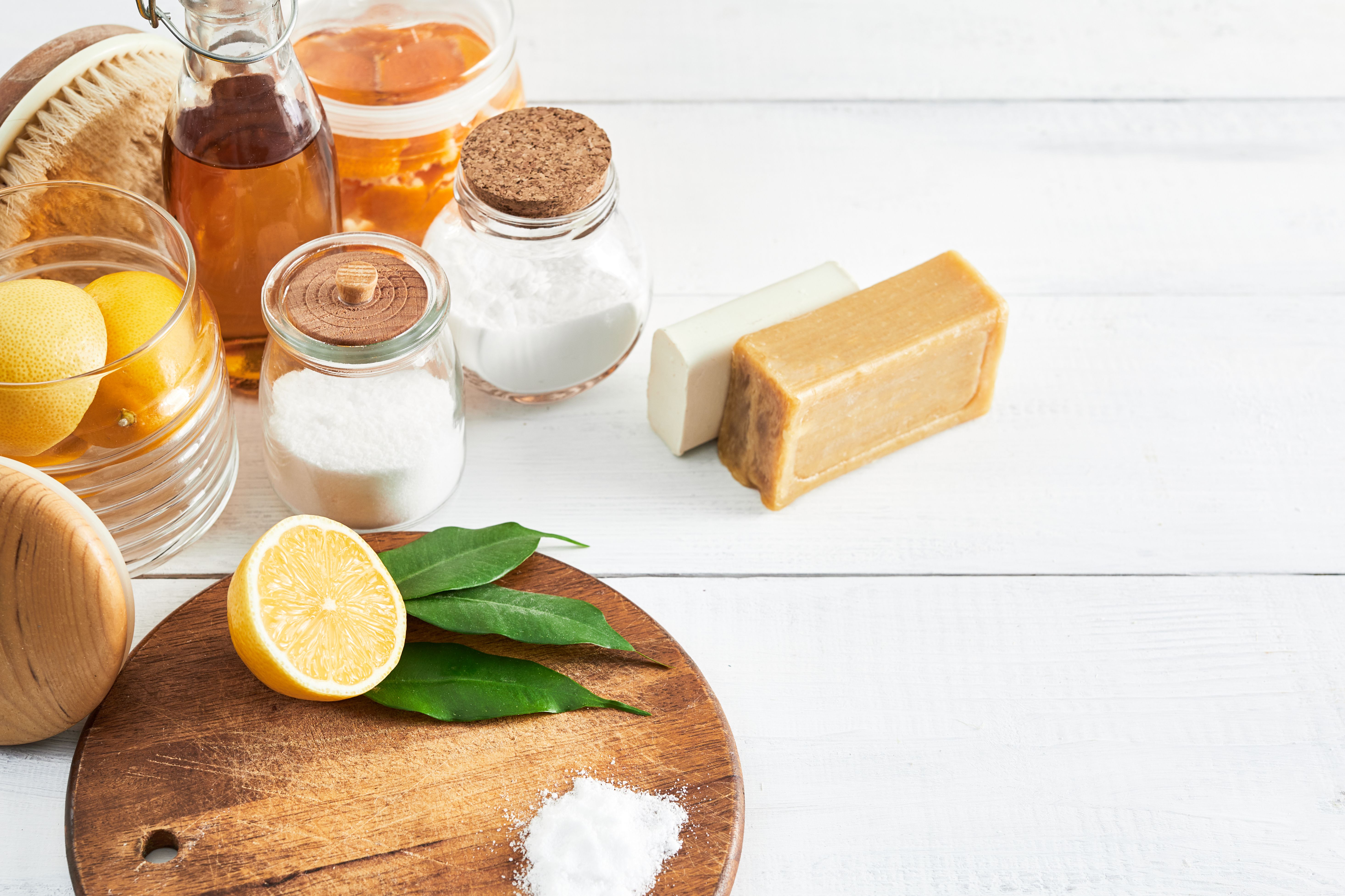 Eco-friendly natural cleaners: baking soda, soap, vinegar, salt, lemon and brush on table. Zero waste concept. Top view.
