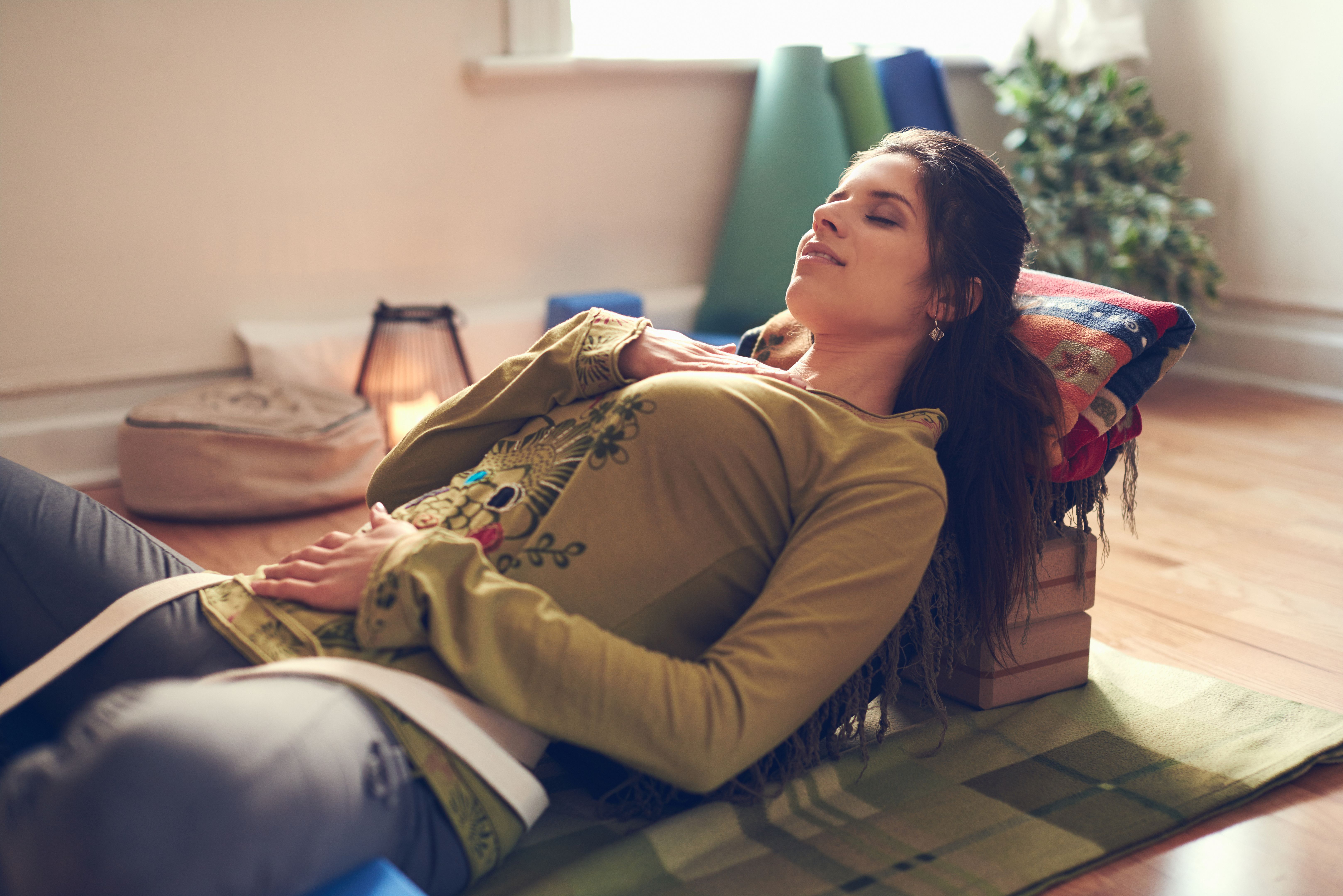Attractive mixed race woman doing restorative yoga Attractive mixed race woman doing restorative yoga