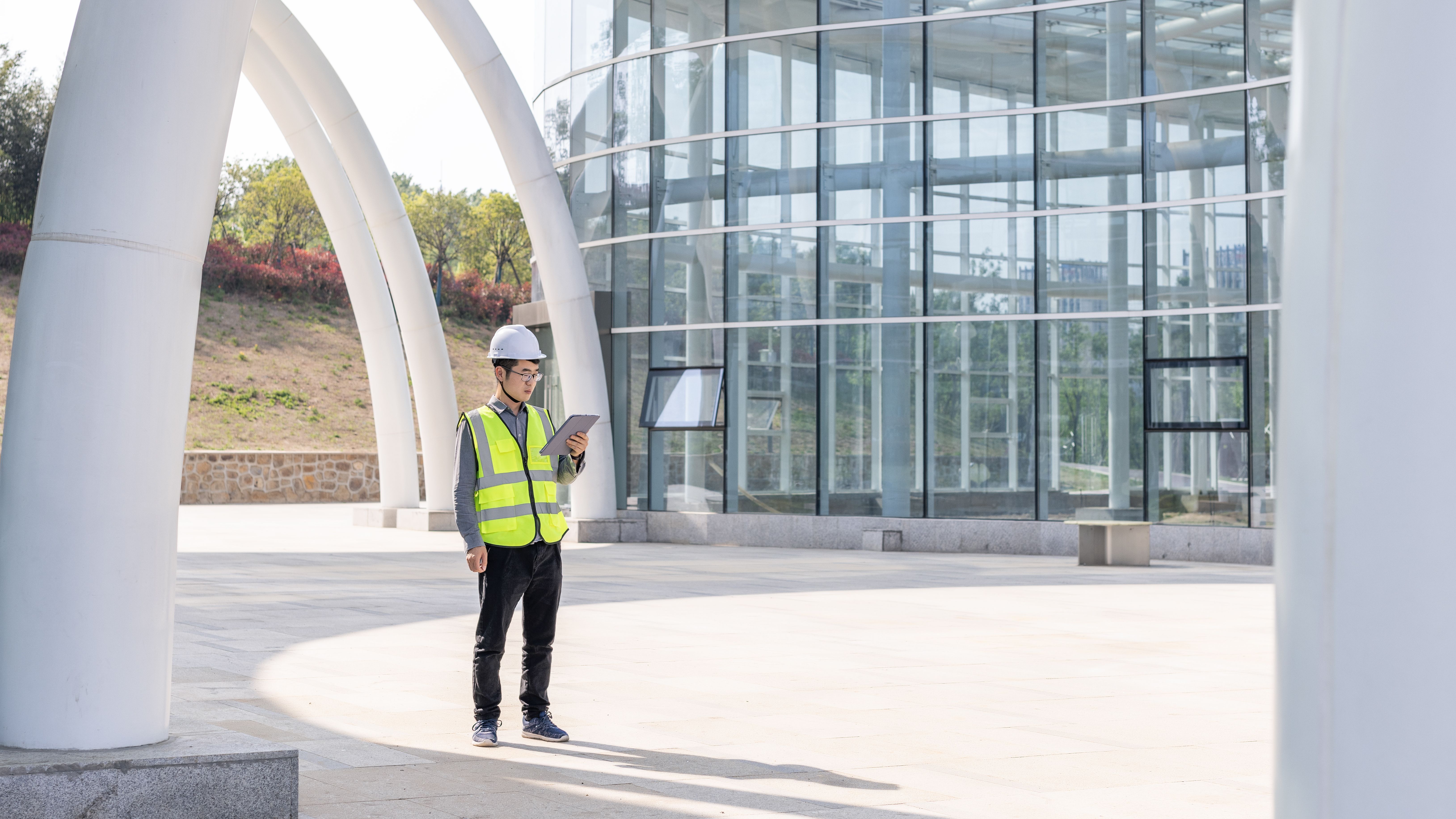 Construction worker in safety vest using tablet outdoors