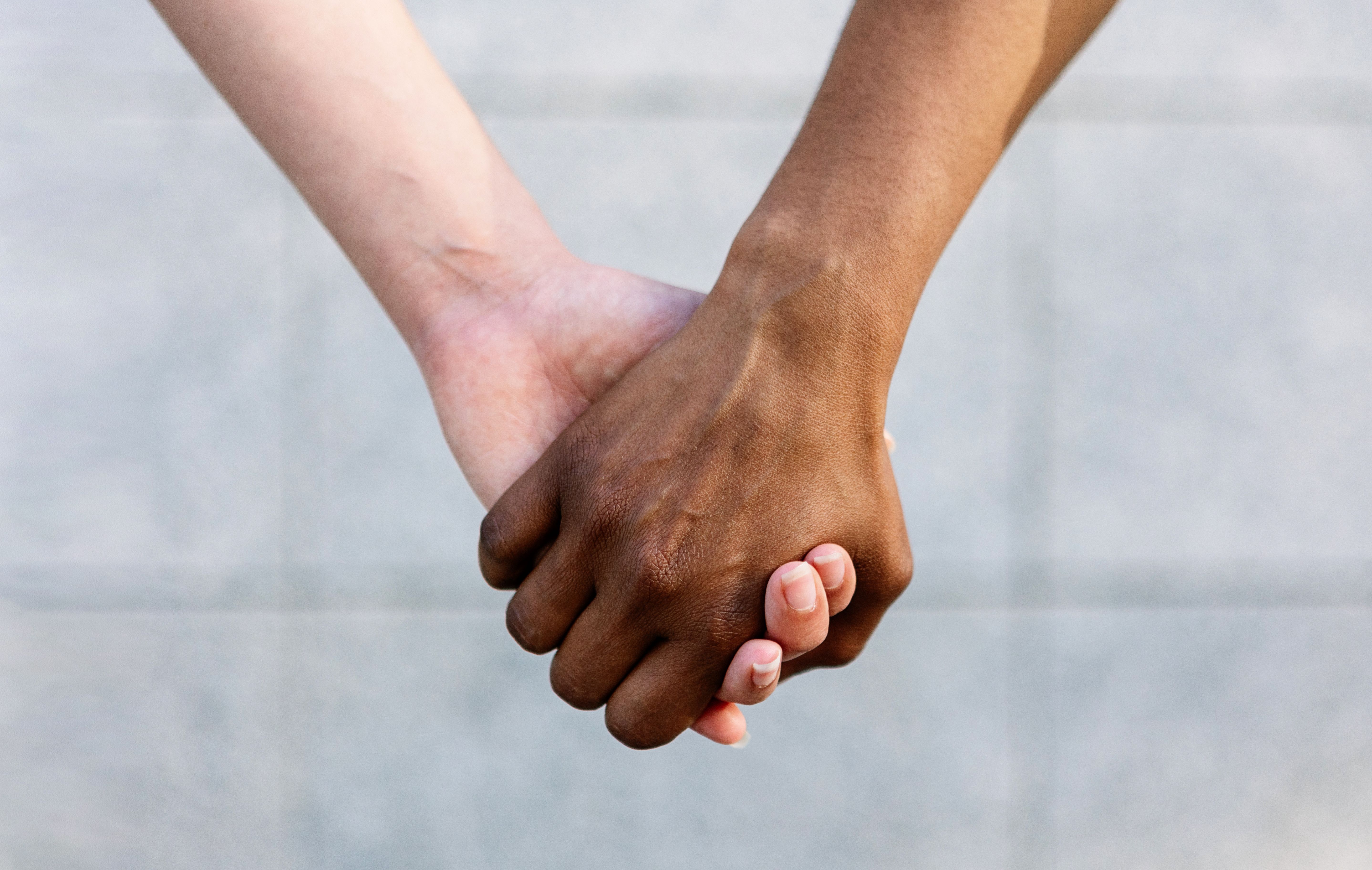 Close up de duas mulheres diversas de mãos dadas mostrando união e apoio