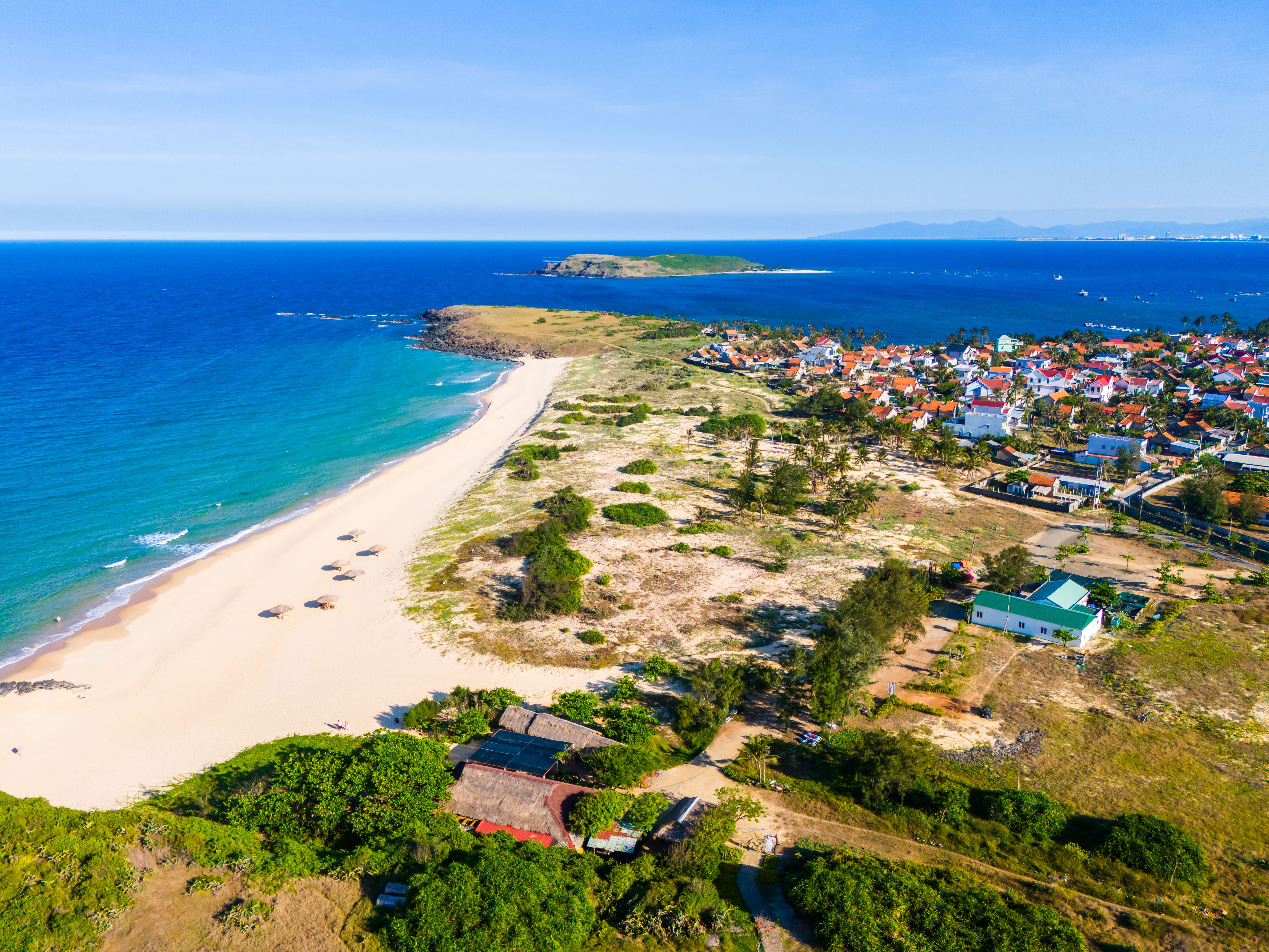 Aerial view of Bai Xep beach in Phu Yen province, Vietnam. Tropical coast from cliff above. Vietnam travel destination, golden sand beach waving sea rock boulders.