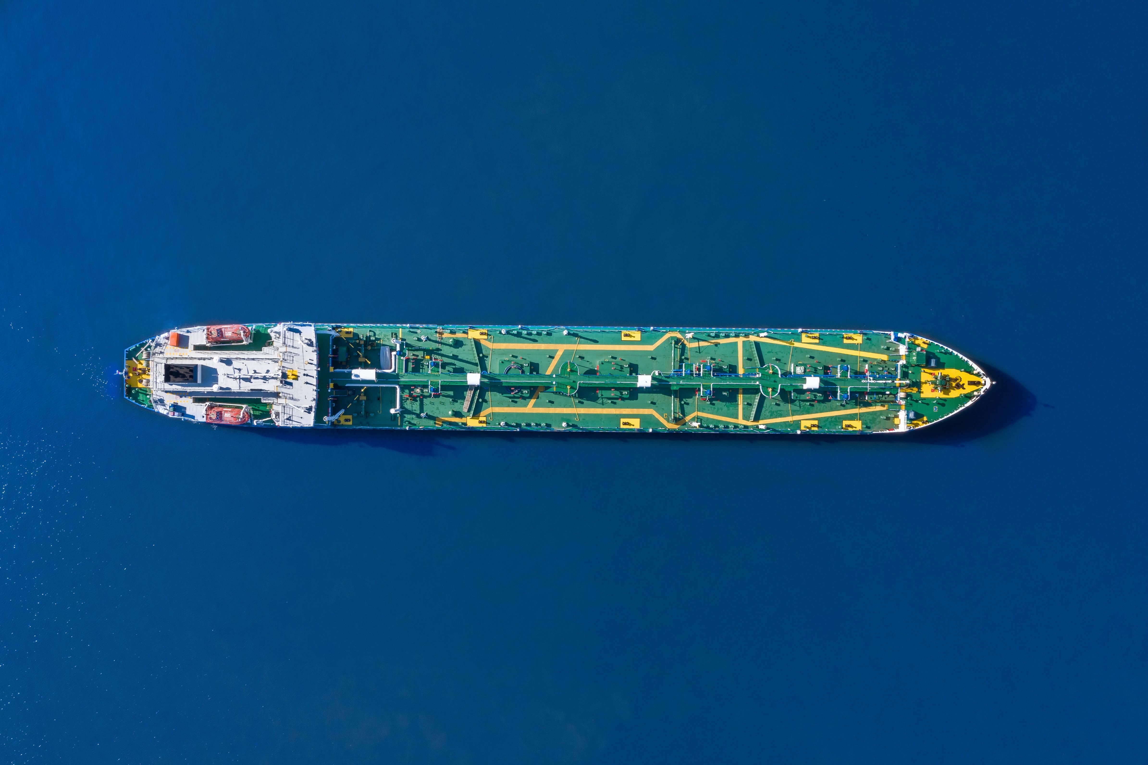 Aerial view tanker ship with liquid bulk cargo is sailing in blue water.
