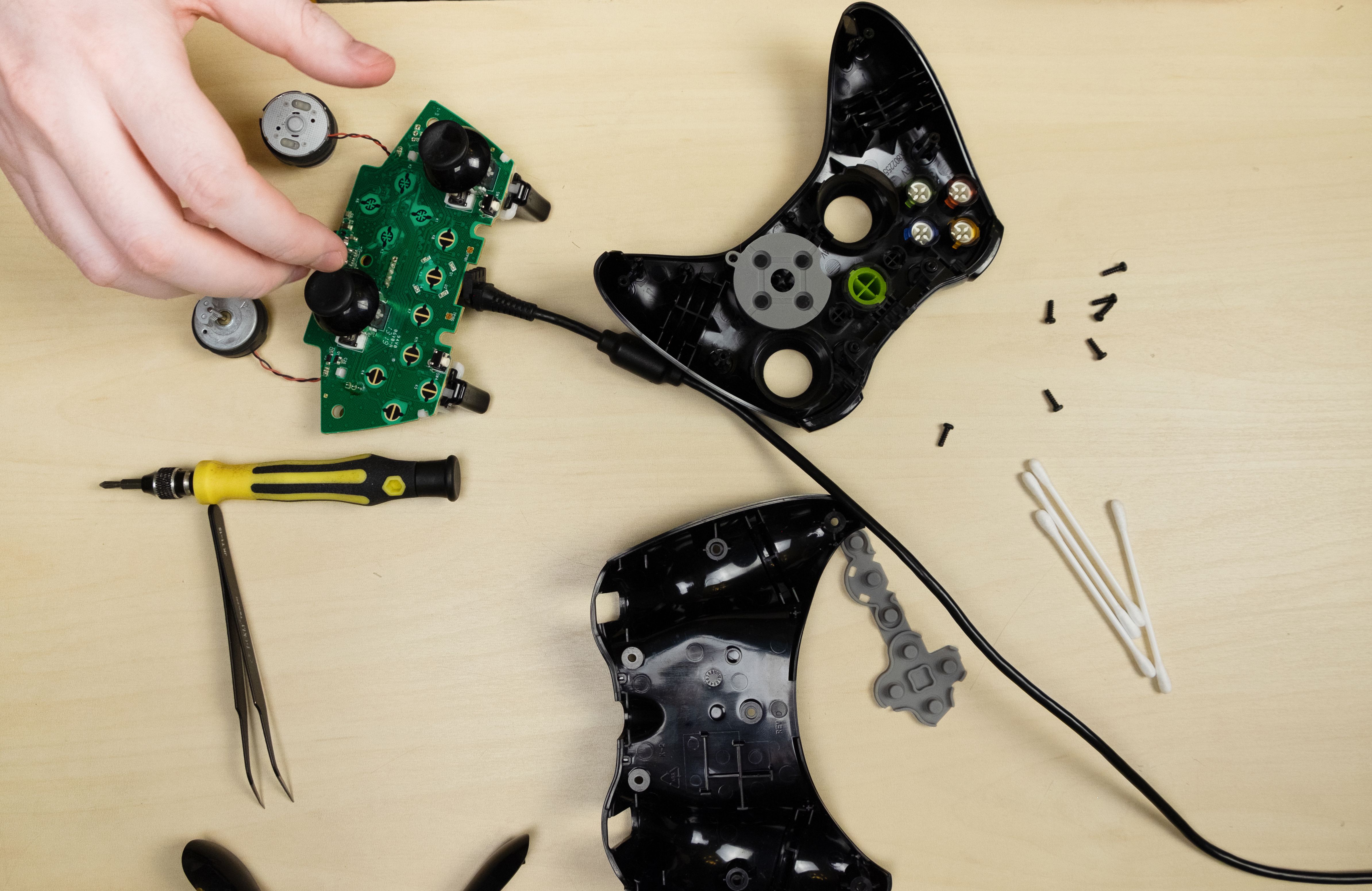 Joystick-gamepad repair, top view. Spare parts, screwdrivers, screws, printed circuit board