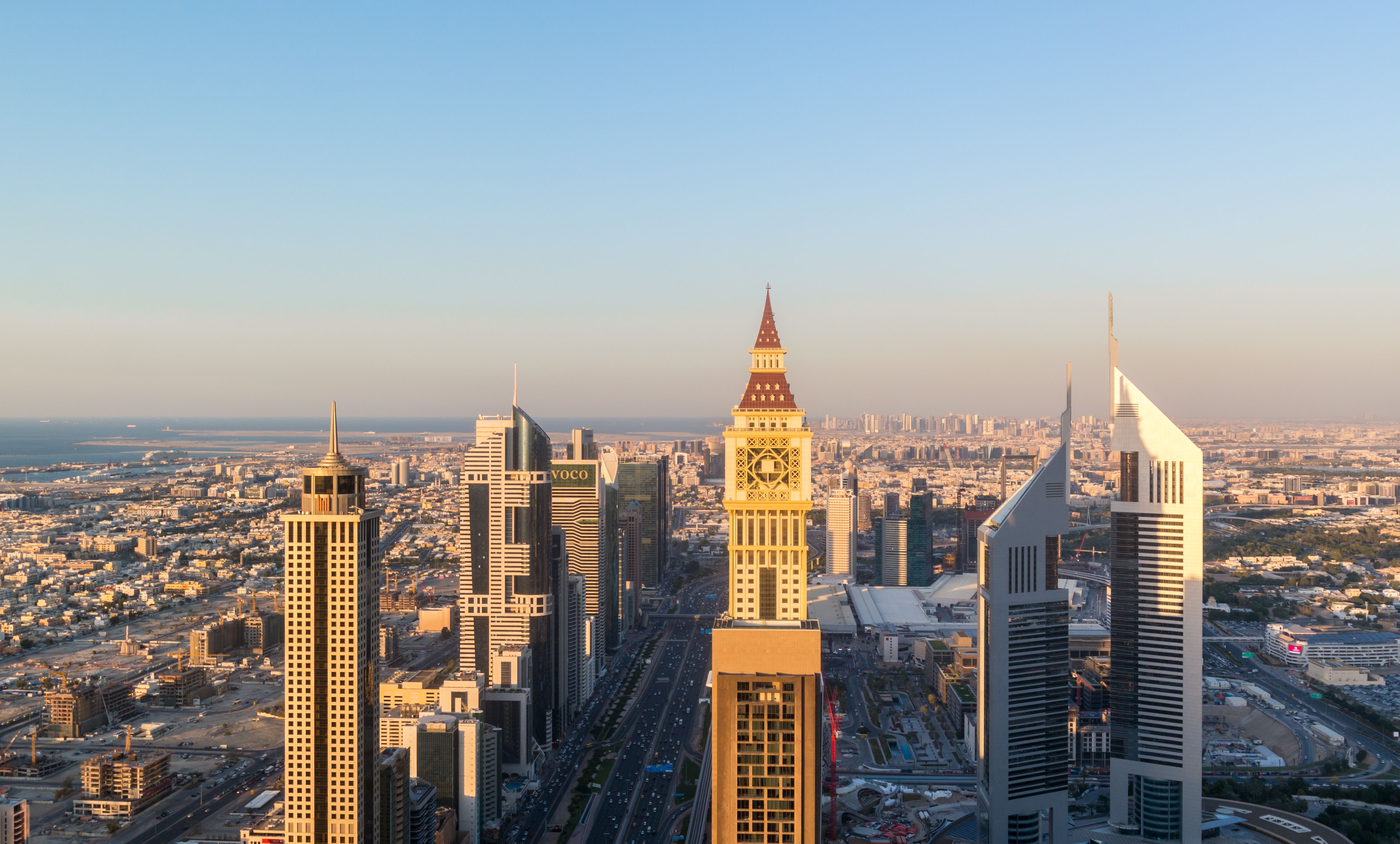 Aerial view of the iconic Sheikh Zayed road Skyscrapers and landmarks - Aerial view of Dubai city roads and Towers at sunset - Gevora Hotel view