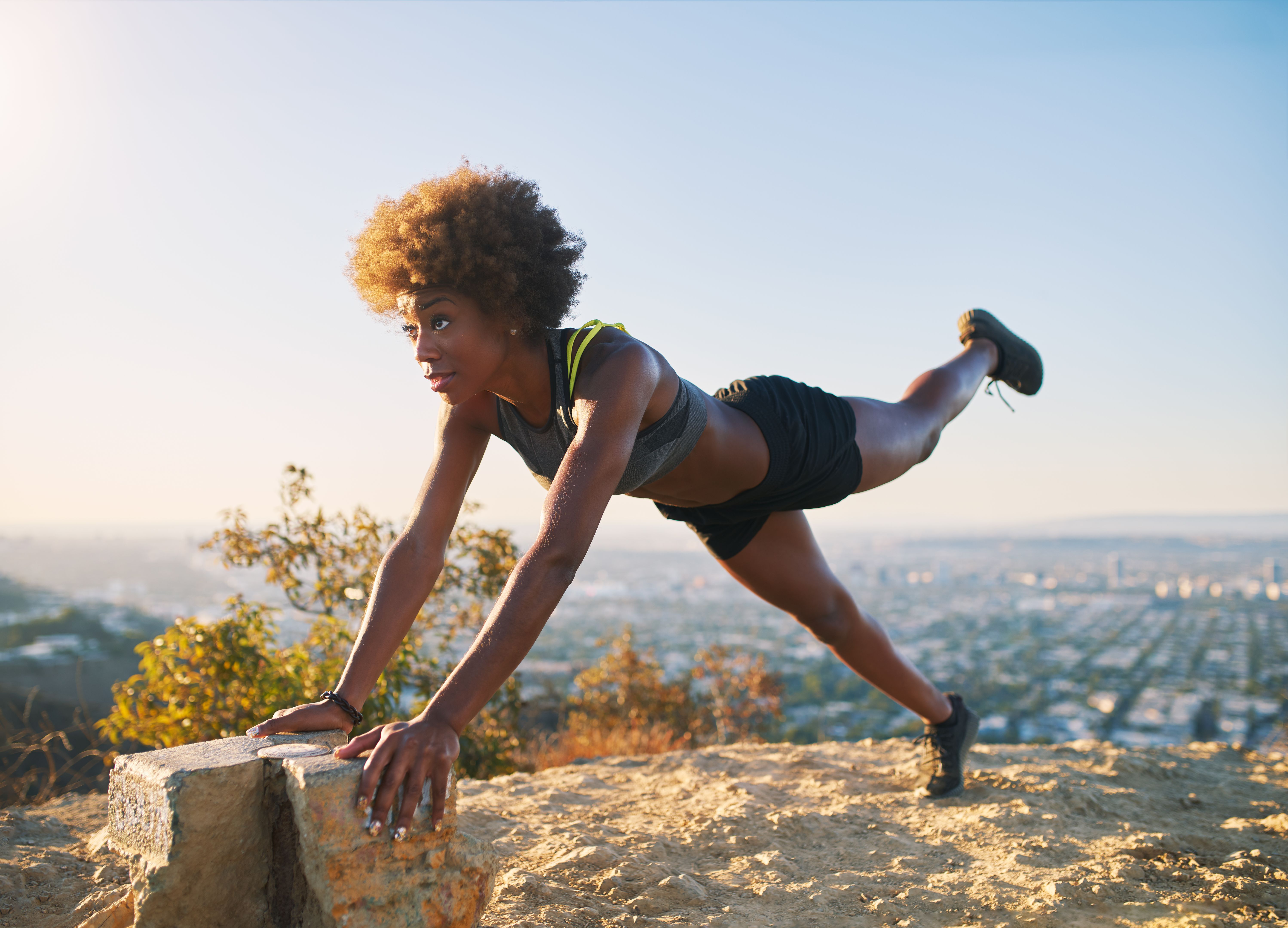 athletic young african american woman doing stretches and pushups at runyon canyon athletic young african american woman doing stretches and pushups at runyon canyon