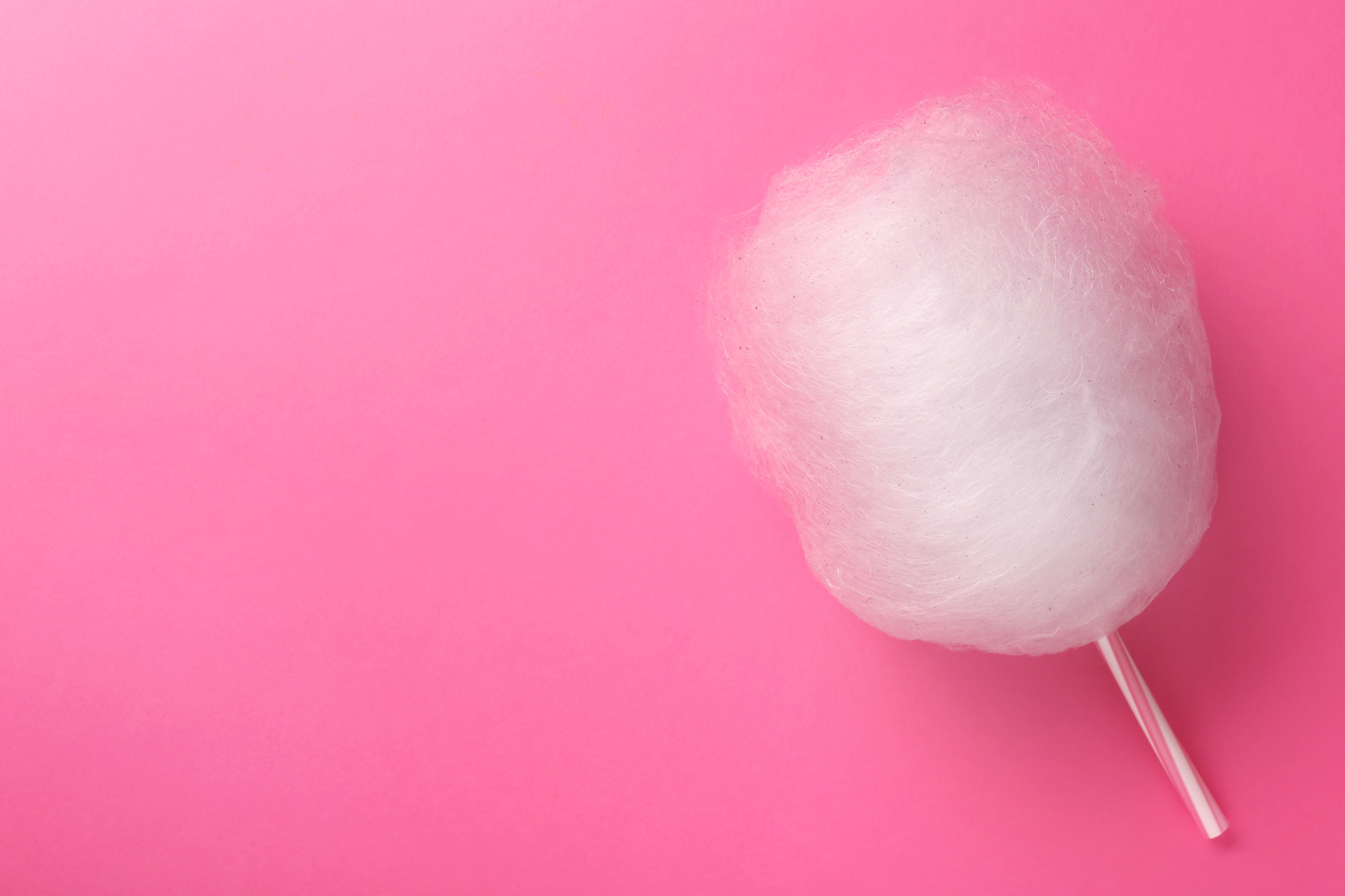 One sweet cotton candy on pink background, top view. Space for text One sweet cotton candy on pink background, top view. Space for text