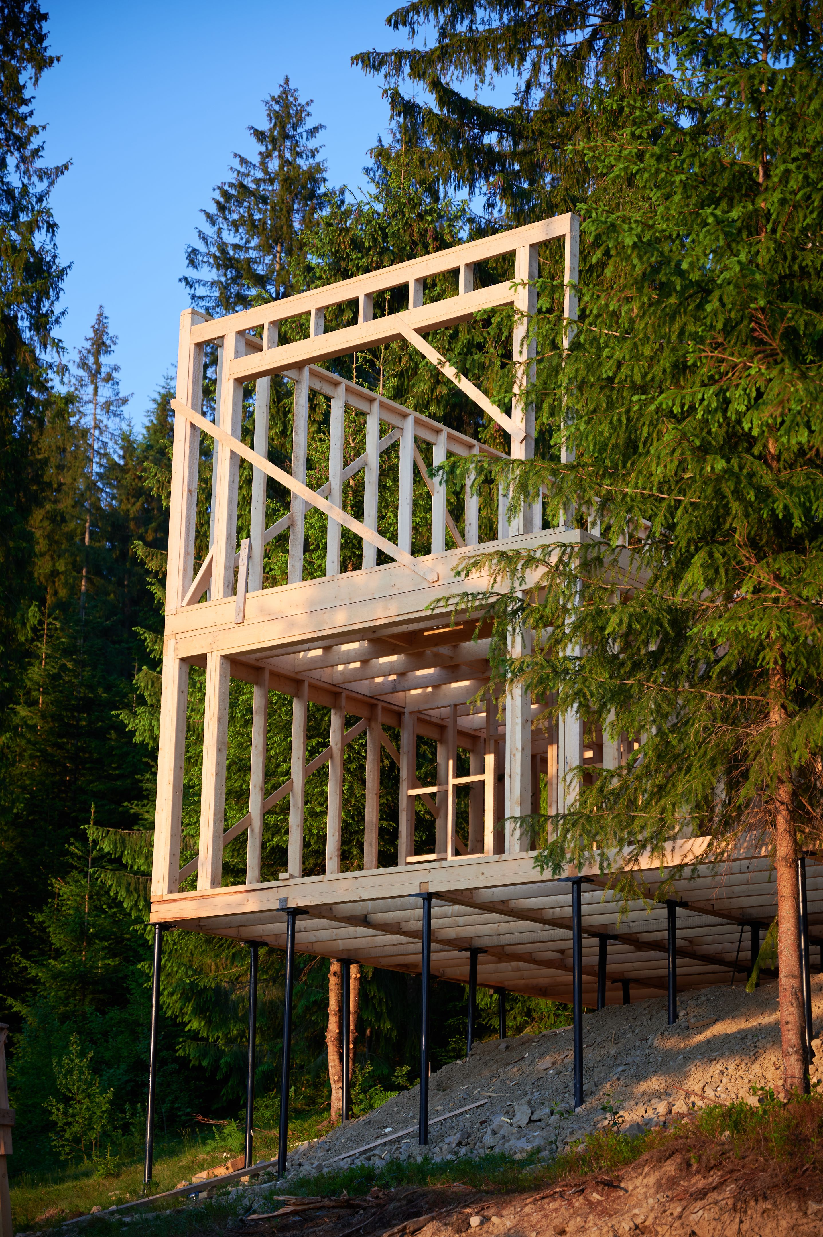 Wooden frame house under construction near forest. Wooden frame house under construction near forest.