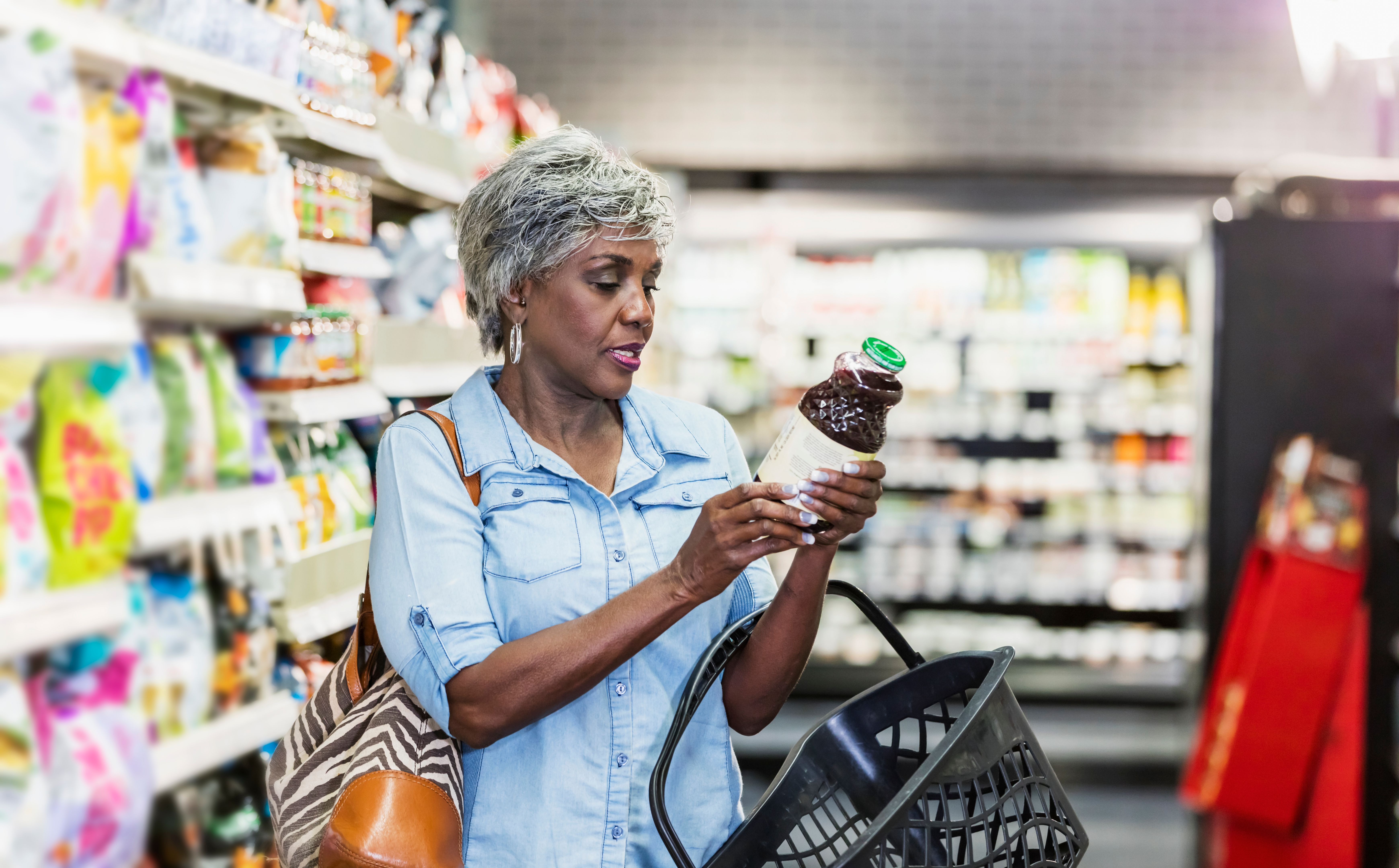 African-American woman in grocery store reading label African-American woman in grocery store reading label