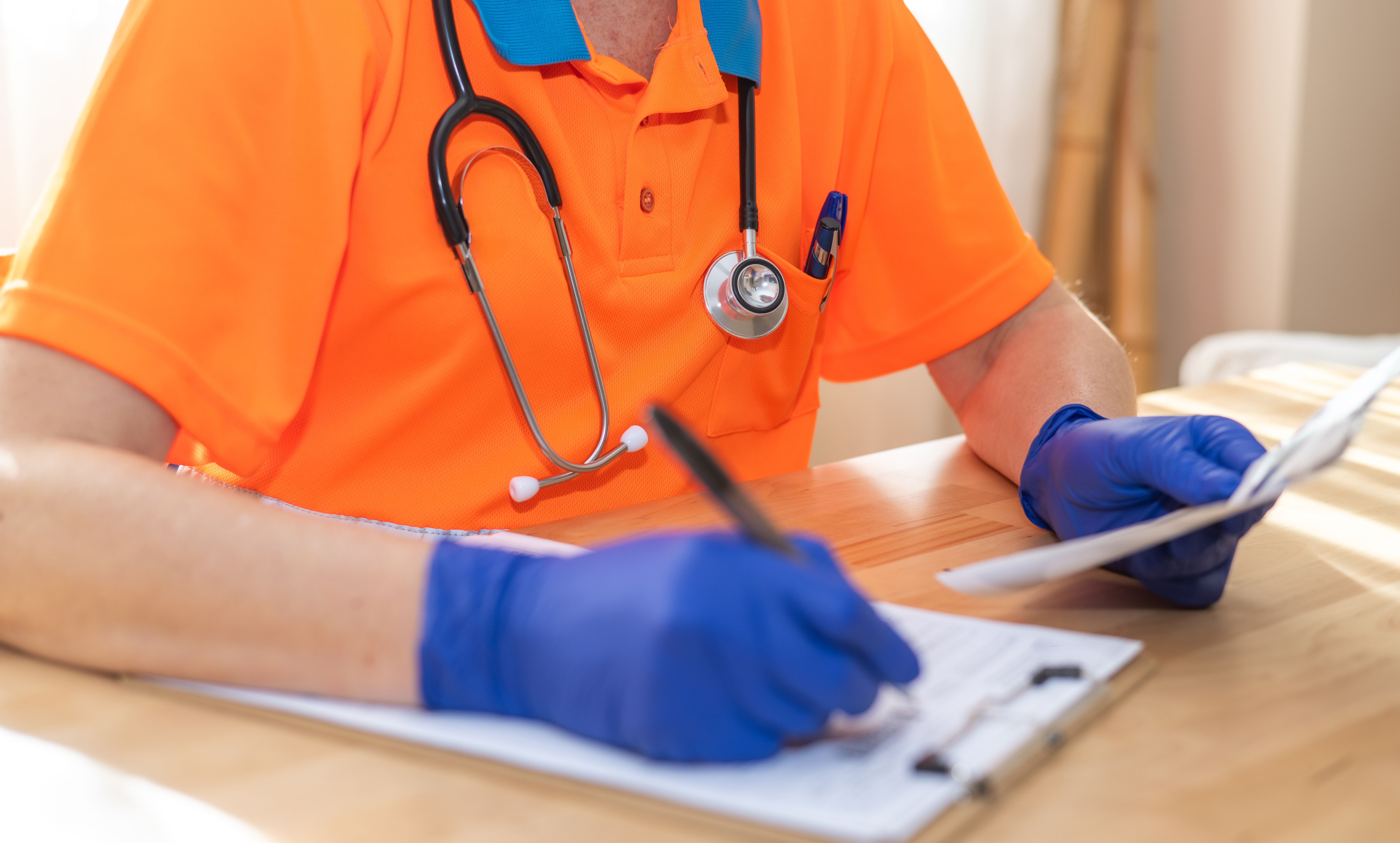 Healthcare professional reviewing compliance documents and completing nonprofit registration paperwork, highlighting the importance of accurate state and IRS filings.