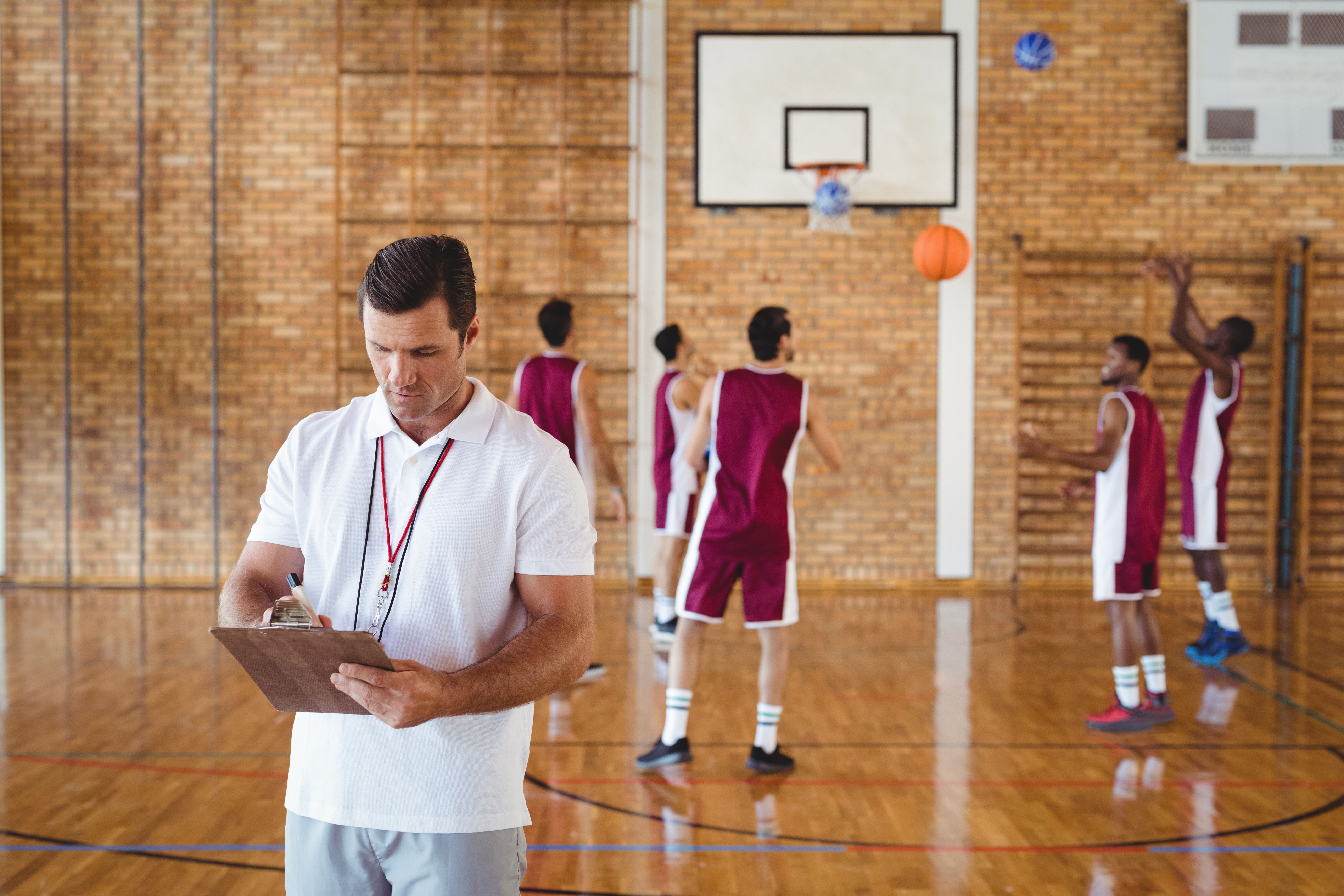 Basketball coach writing on clipboard