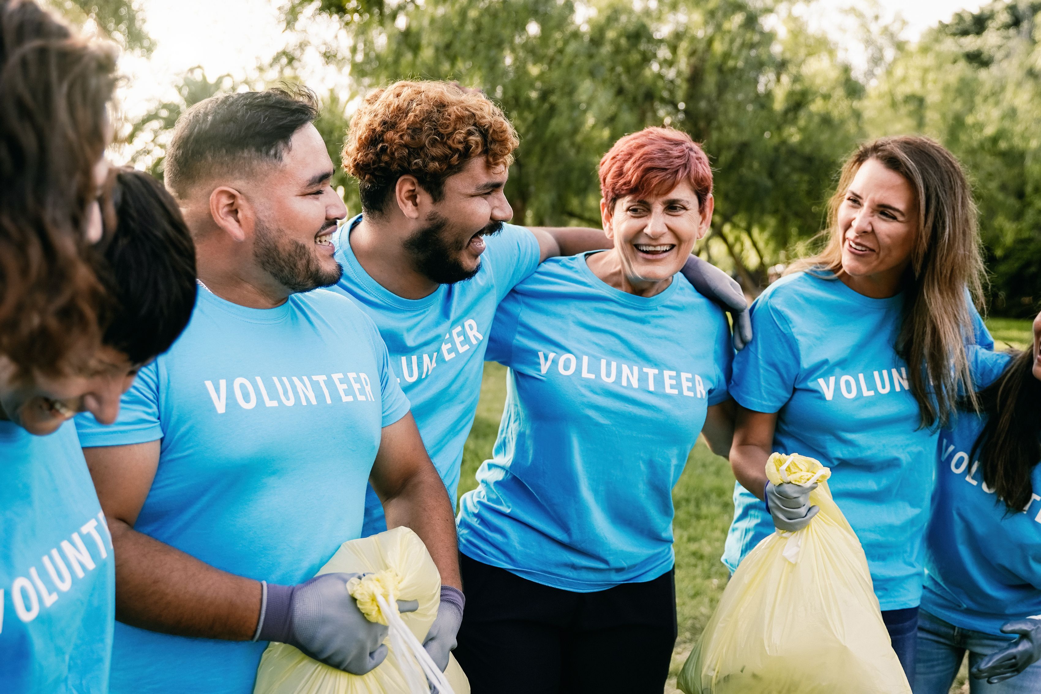 Environmental activists picking up garbage trash at park city. Group of multiracial volunteers cleaning and doing community service Environmental activists picking up garbage trash at park city. Group of multiracial volunteers cleaning and doing community service